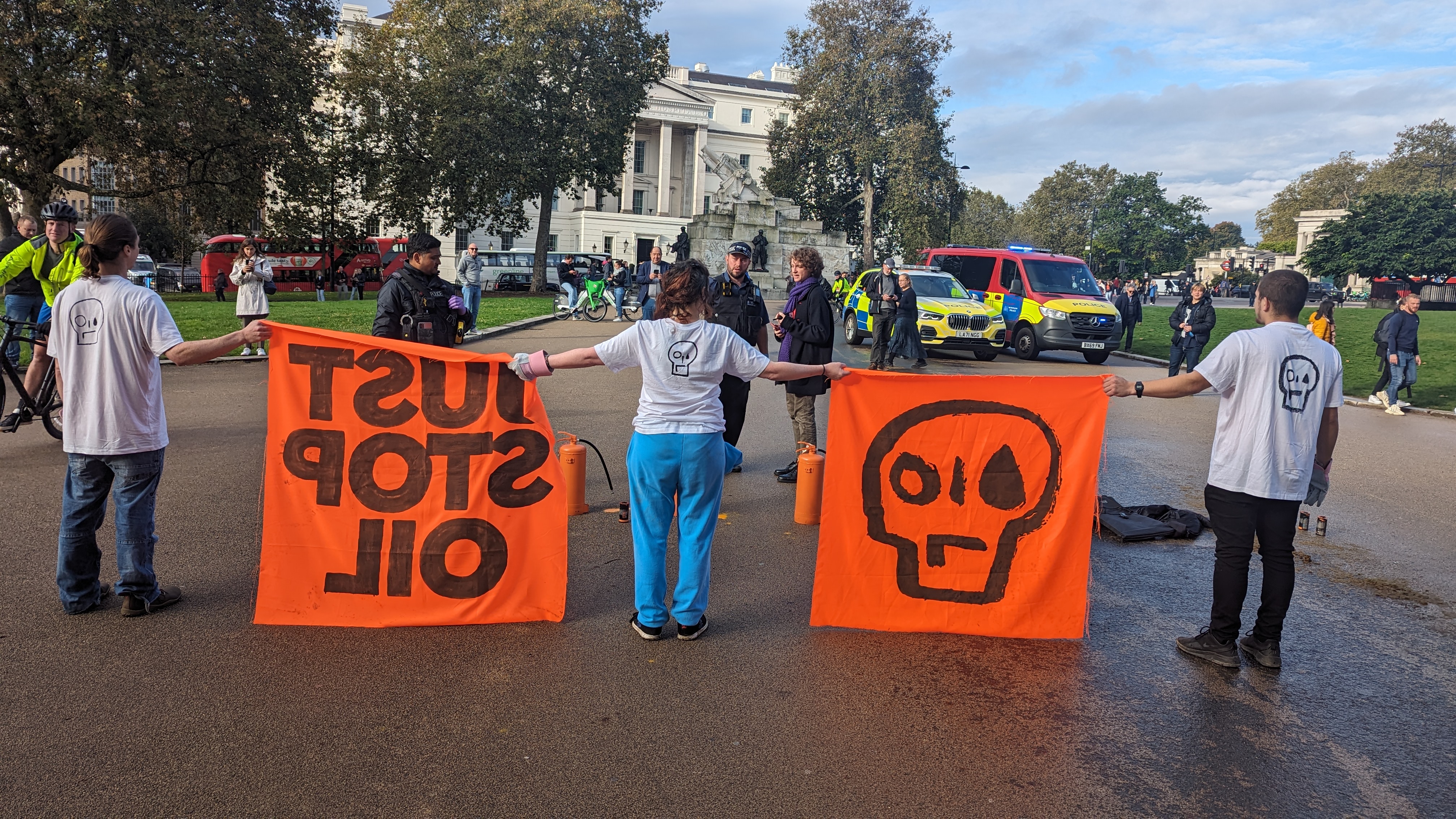 The back view of a protester holding two orange JSO banners.