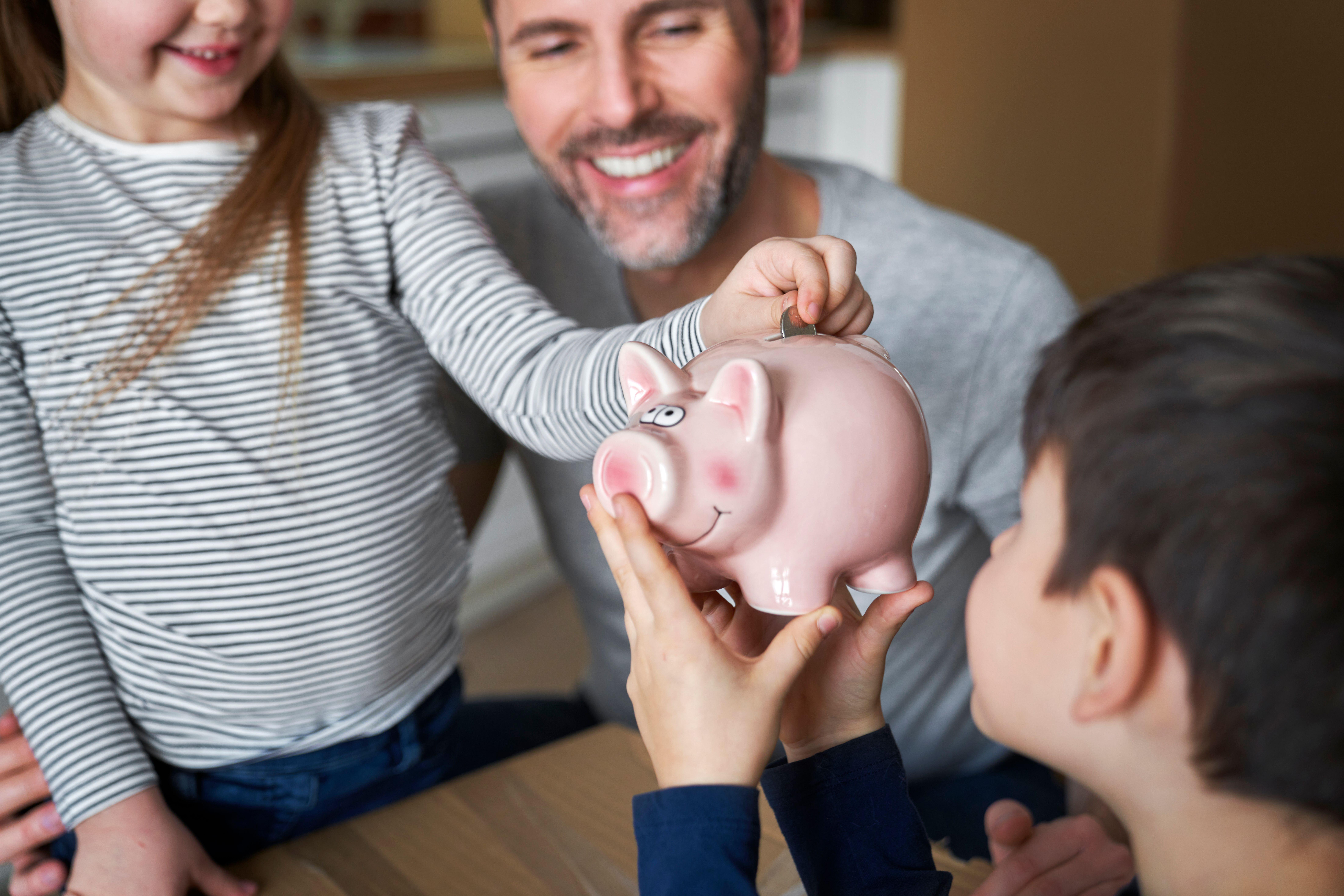 Family saving money using a piggy bank