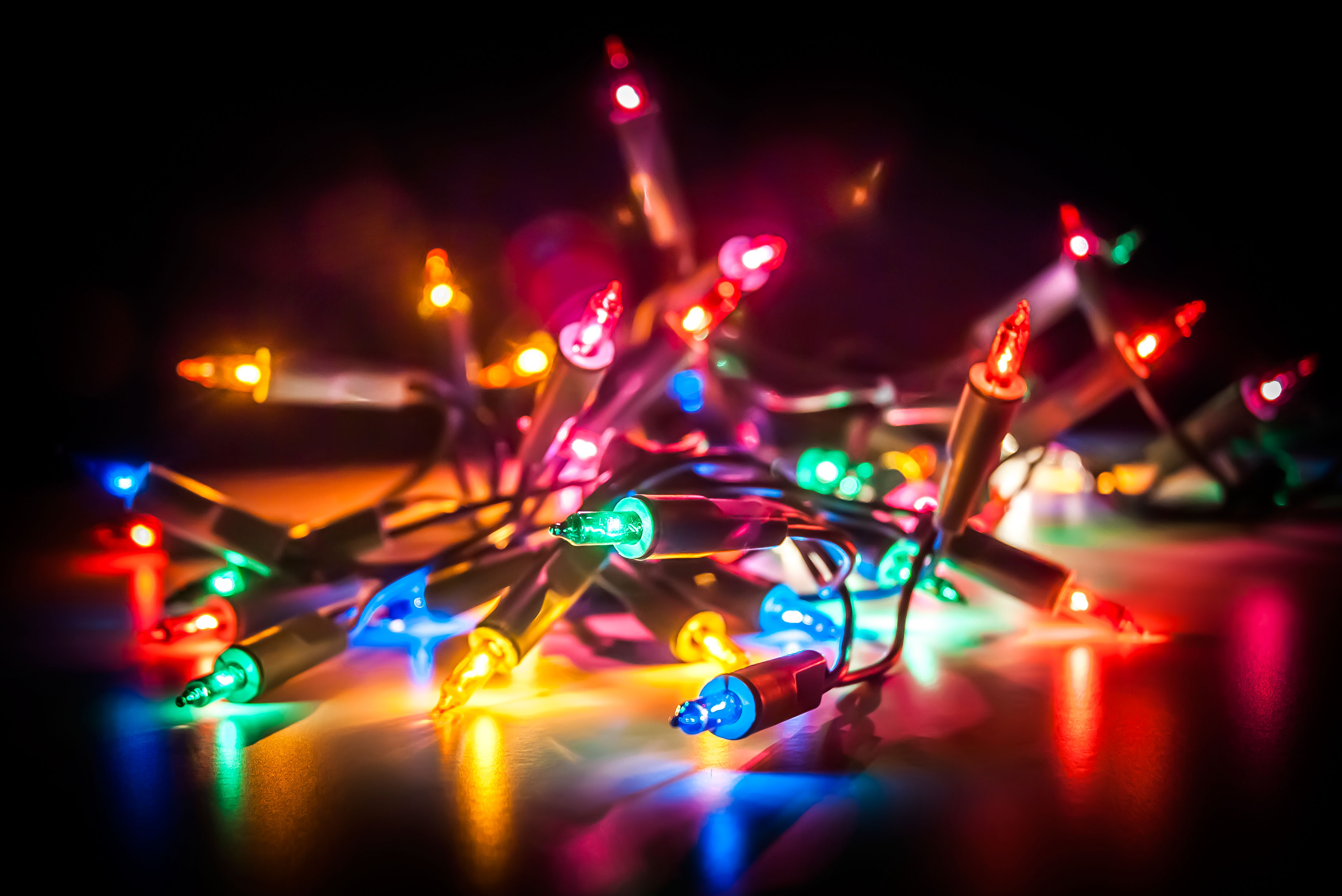 Christmas fairy lights isolated on reflecting surface (Alamy/PA)