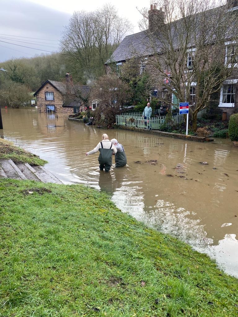 Mario Thomas and his wife Lisa wading through flood water on their way to the pub