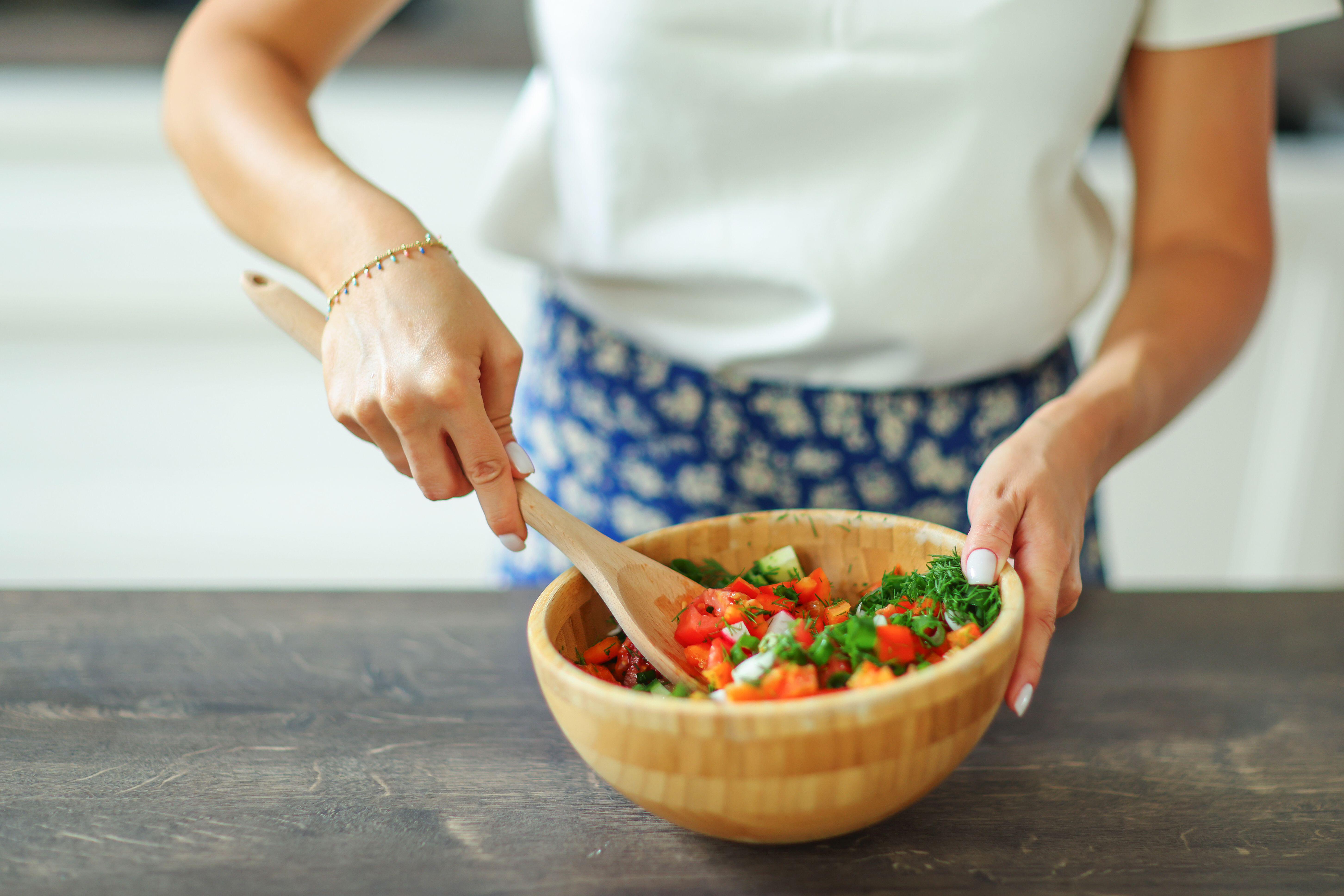 Female hands mixing green salad in the bowl (Alamy/PA)