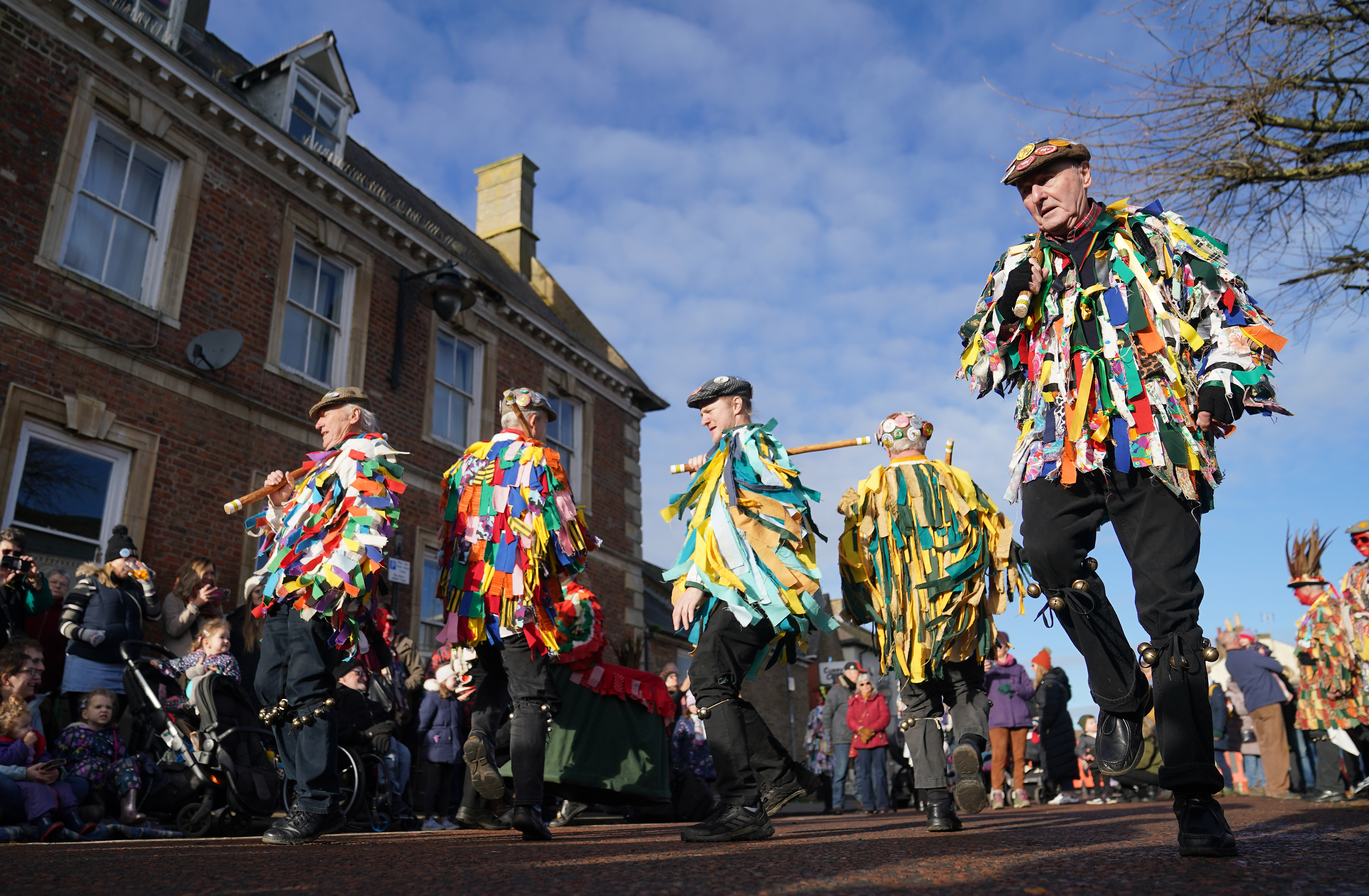 Morris dancers performing in the street wearing colourful attire