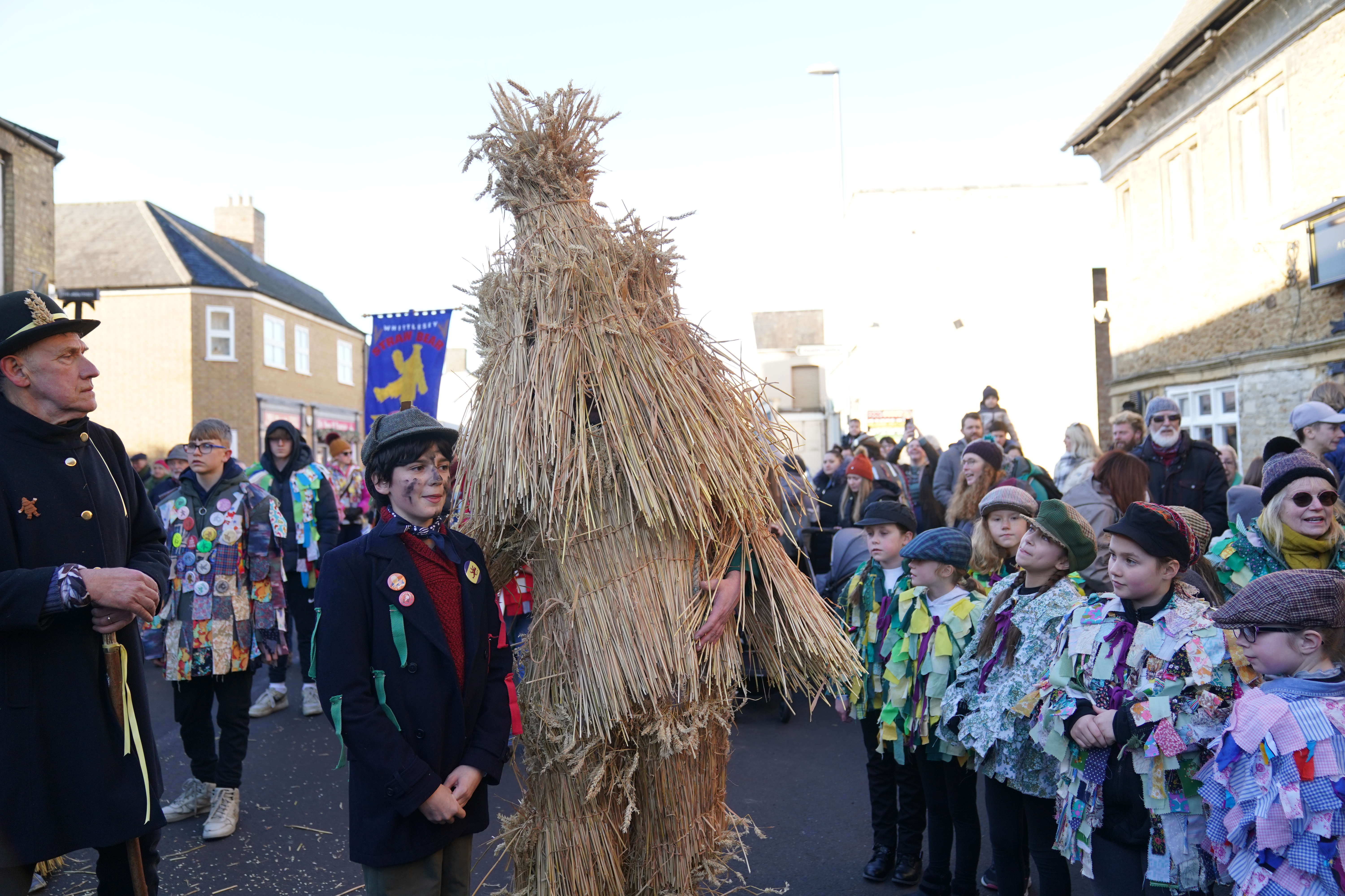 The Straw Bear standing with members of the procession during the festival 