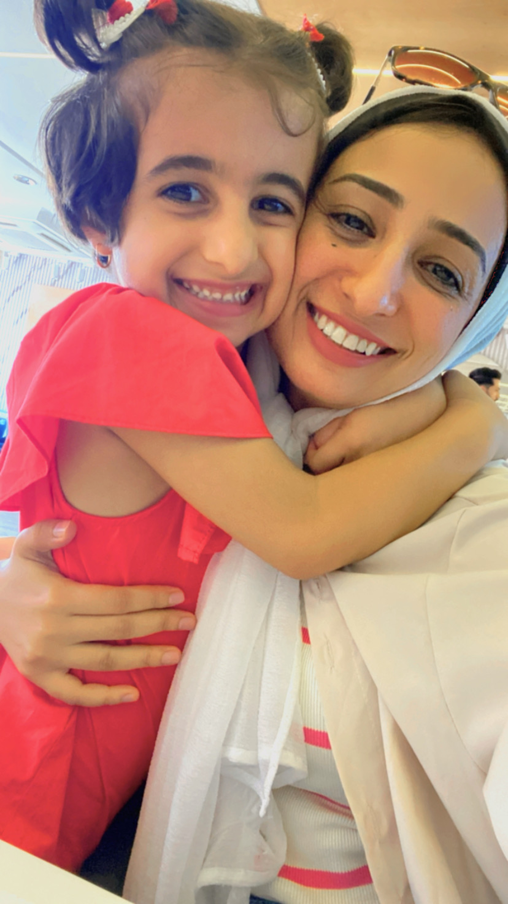 Israa and her daughter Marlin hugging and smiling at the camera