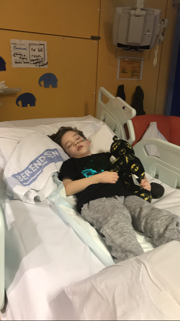 A young boy lying in a hospital bed