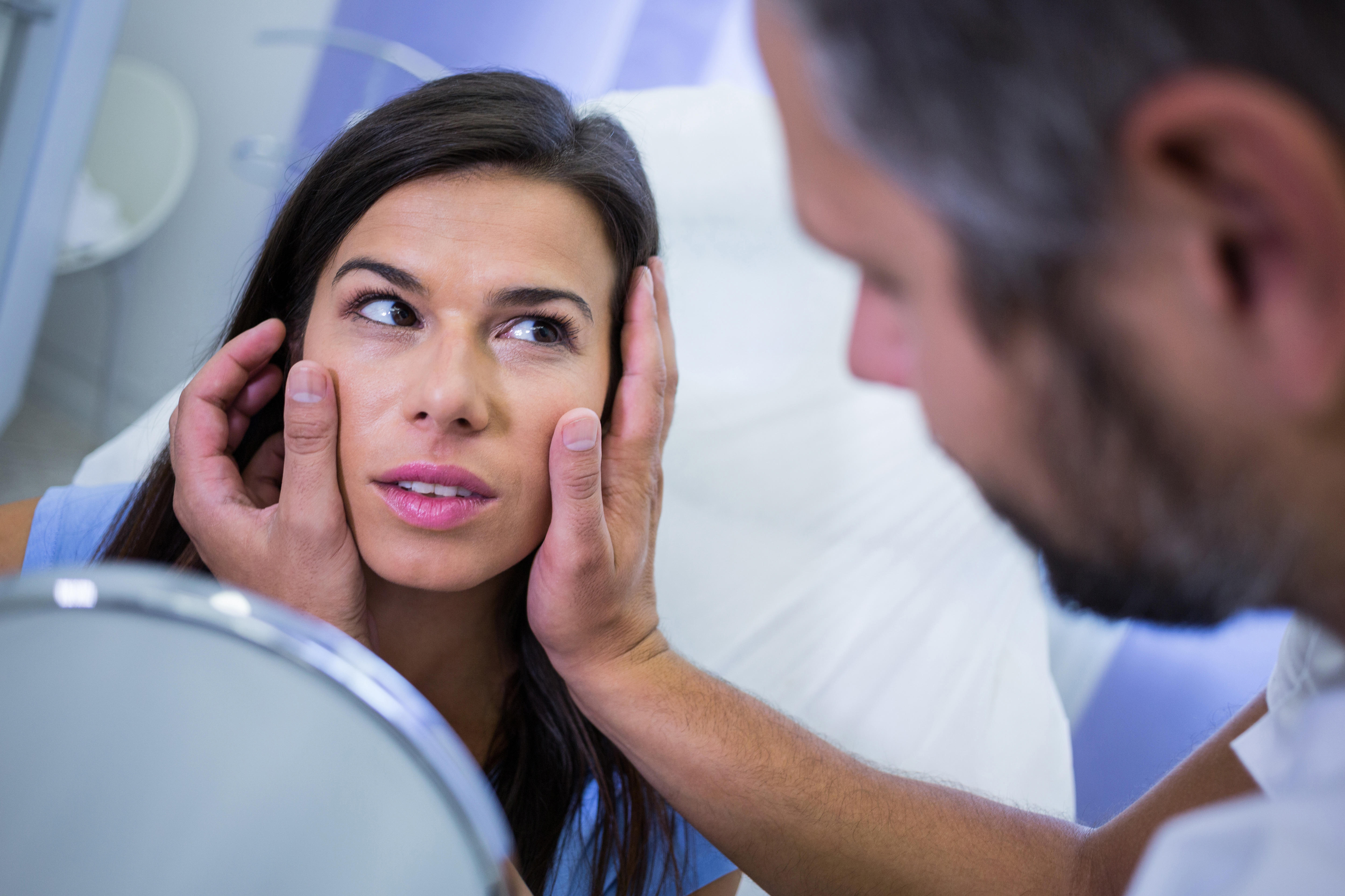 Doctor checking patients skin after cosmetic treatment