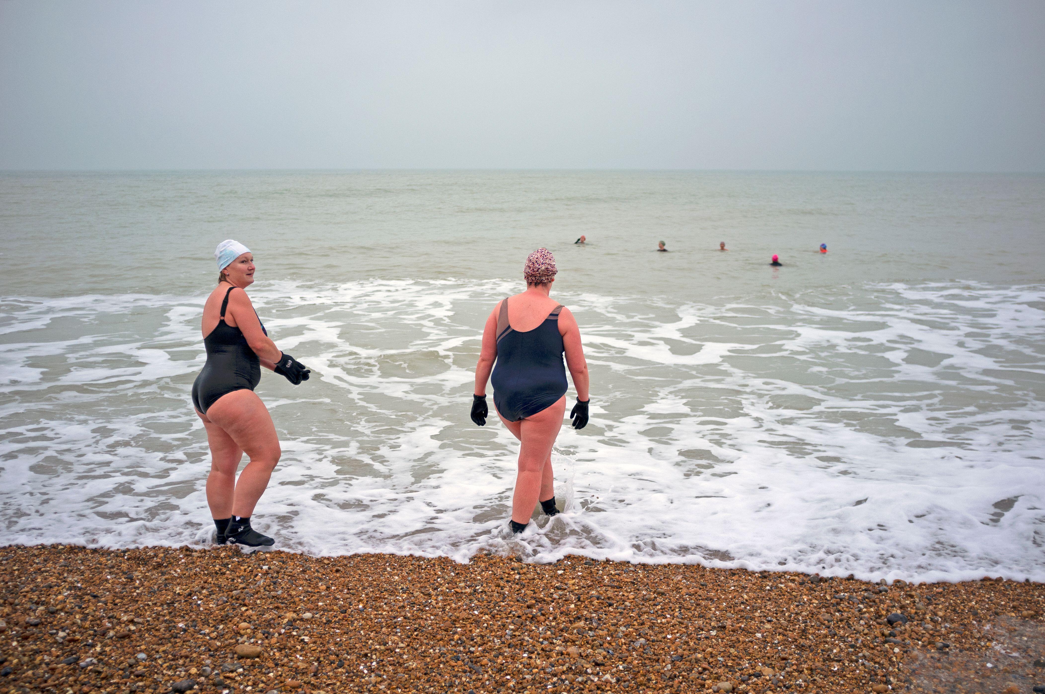 Two women going for a swim in the sea in Brighton