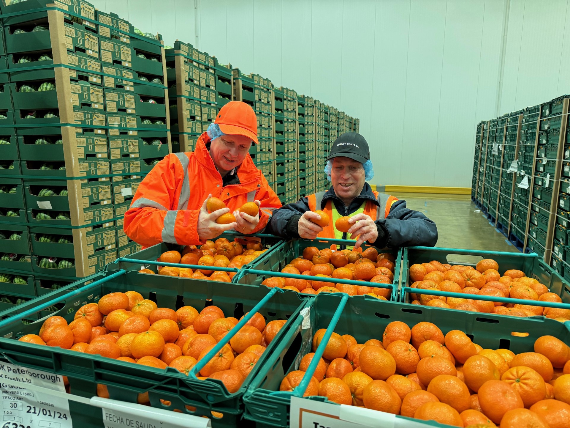 James Cackett from Tesco and Bennie Smidt from AM Fresh check the quality of the new mandarin hybrid fruit. (Tesco/ PA)