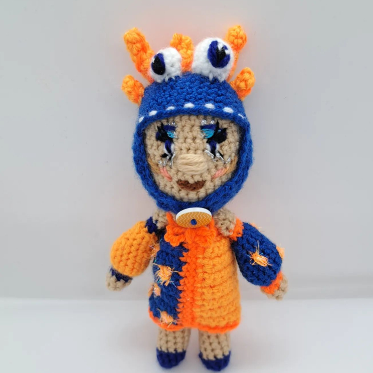 Crocheted doll wearing colourful dress