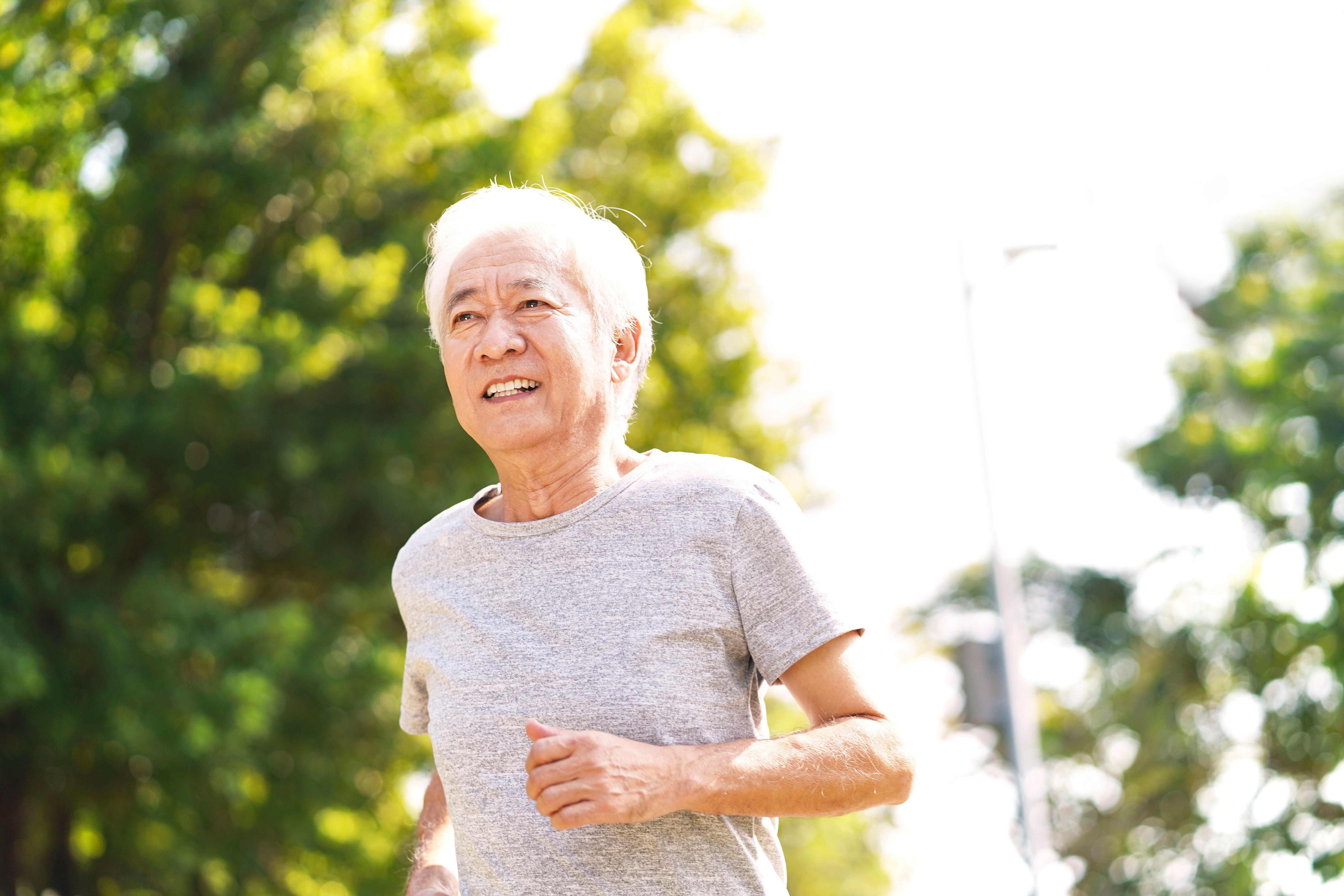 healthy senior asian man running exercising outdoors