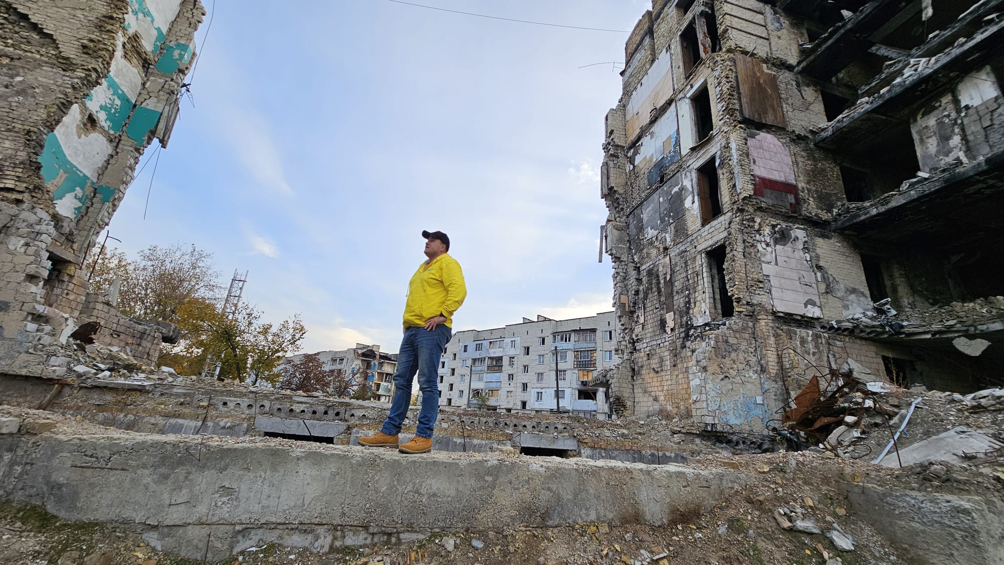 Man stands between two derelict buildings in Ukraine