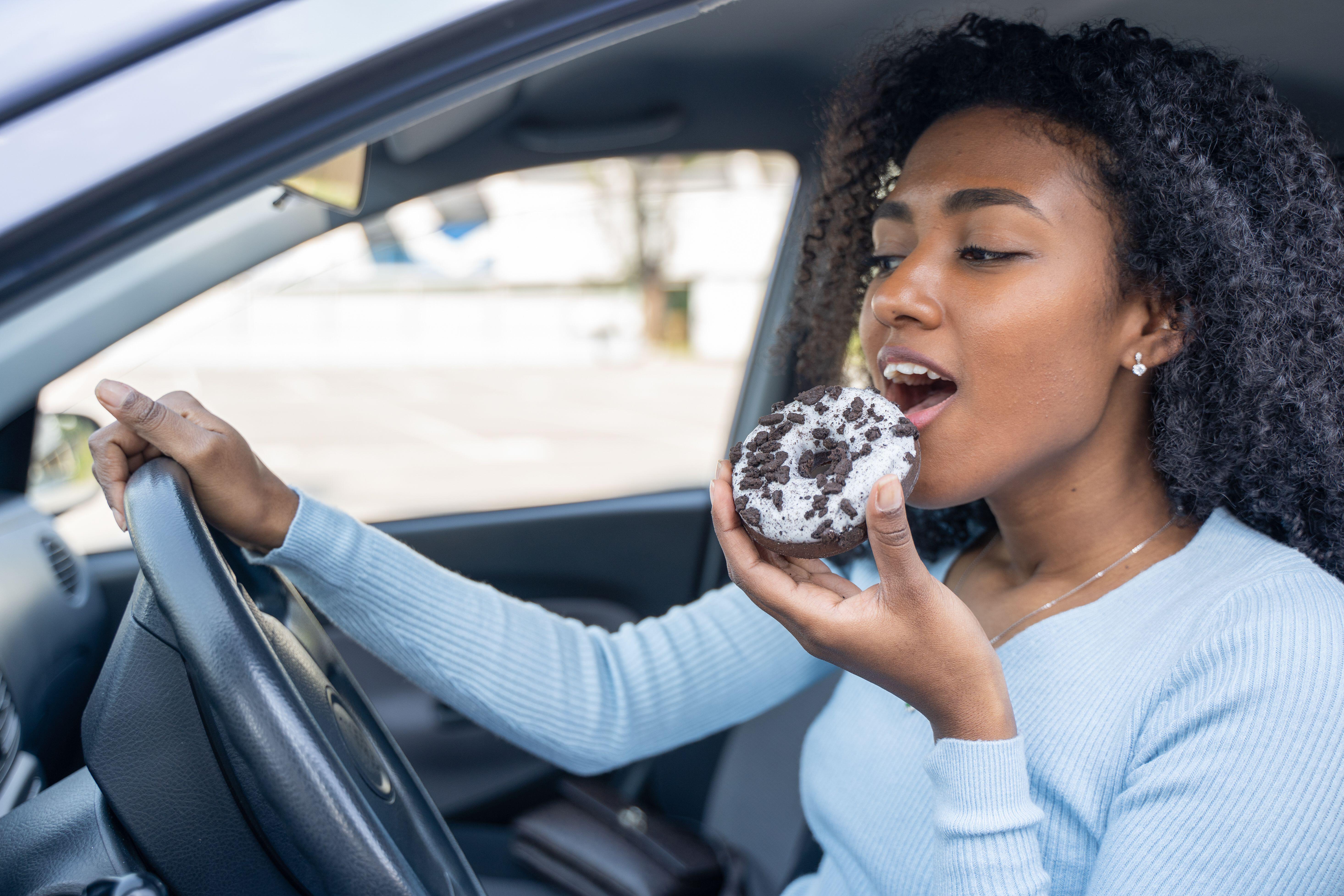 One black woman smiling eating a doughnut