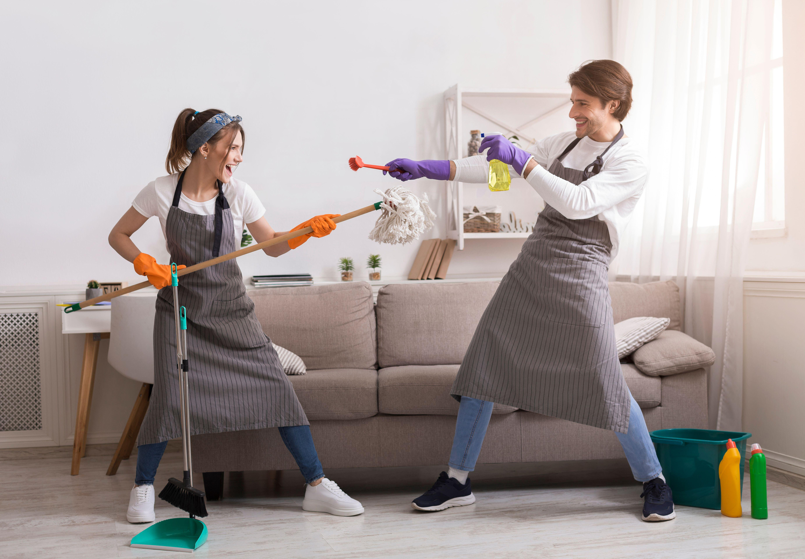 Couple fooling together while spring cleaning