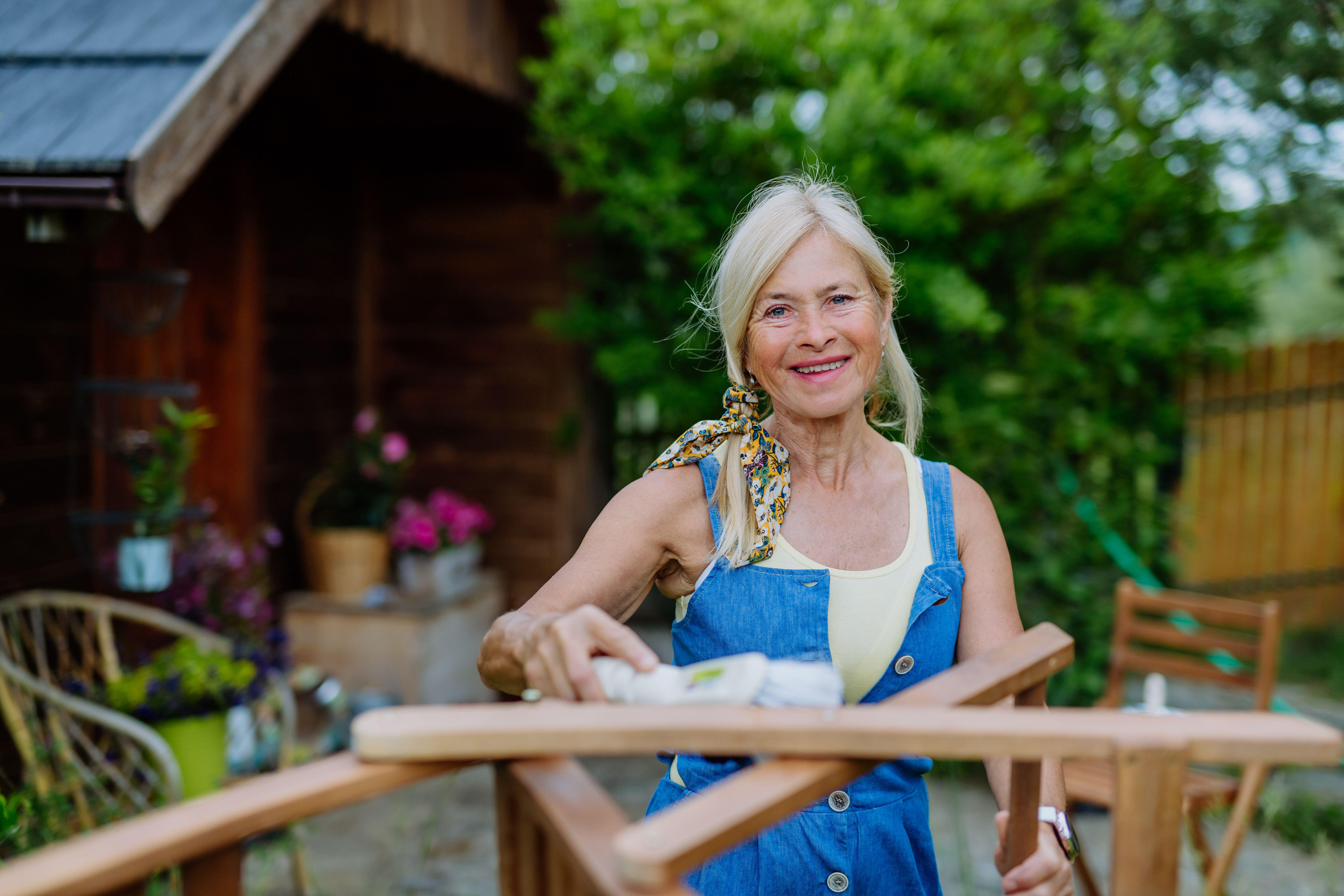 Woman spring cleaning garden furniture 