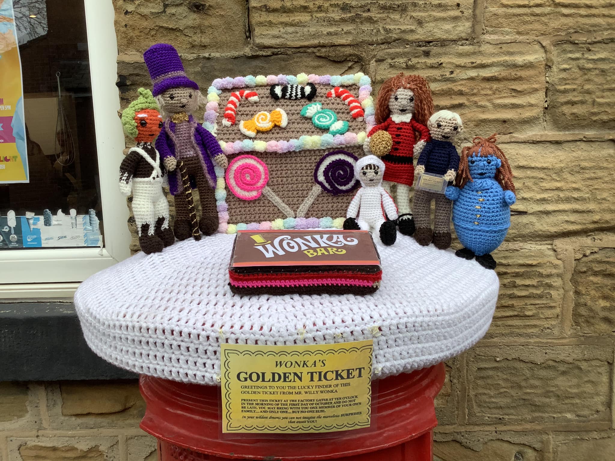 Crocheted items on top of postbox