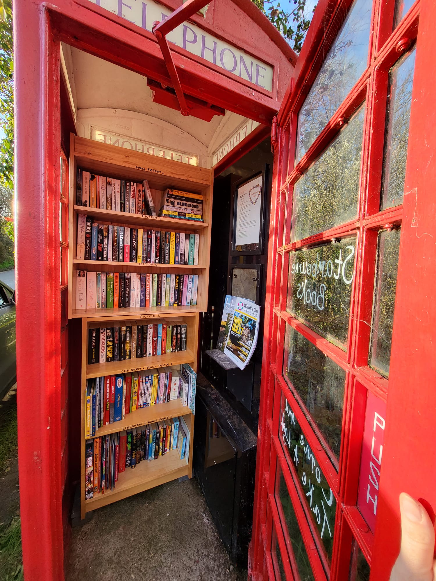 Open telephone box with books inside 