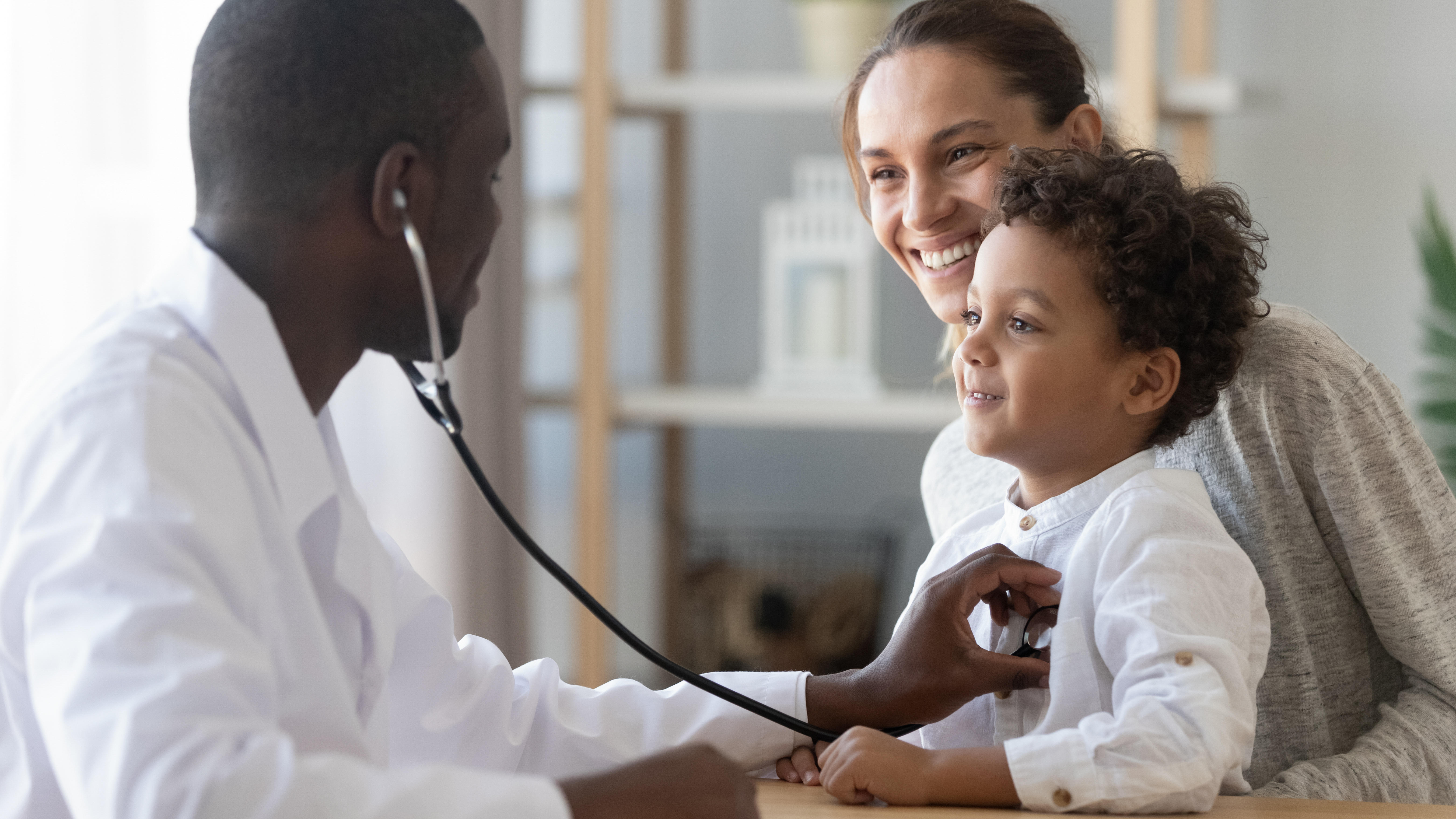 Doctor using stethoscope to listen to child's chest