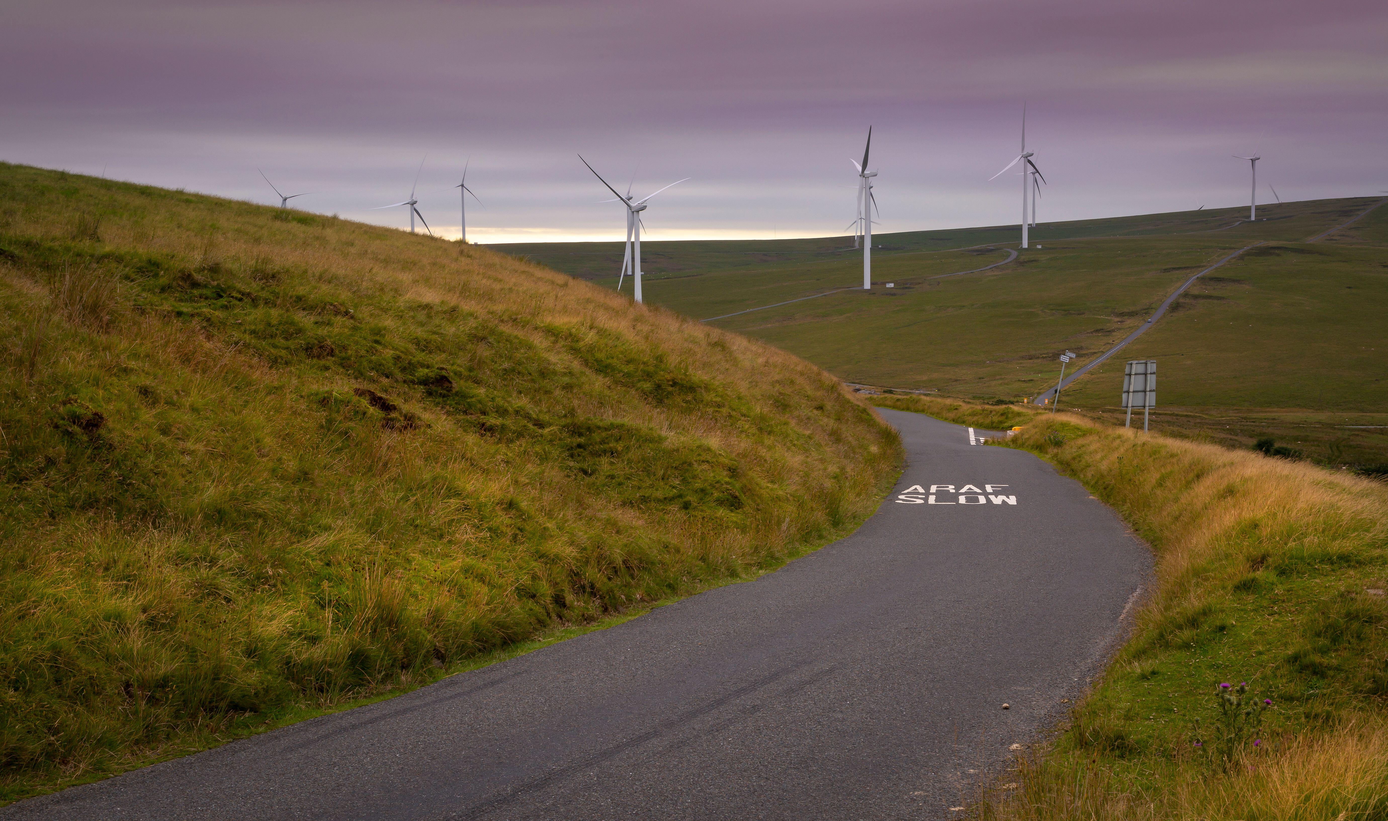 Road between wind turbines on a hill in Wales