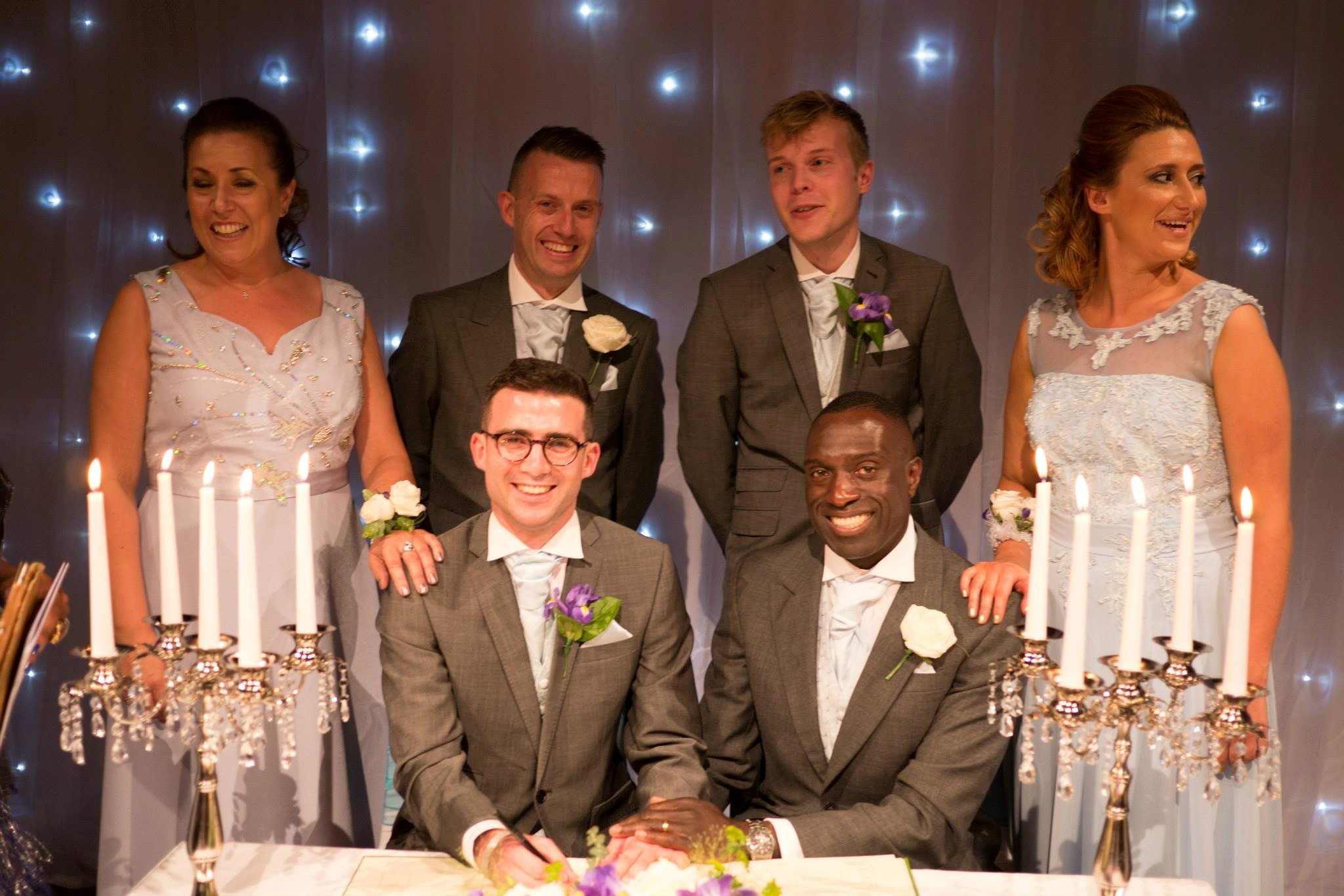 Same-sex couple pictured with their friends and family