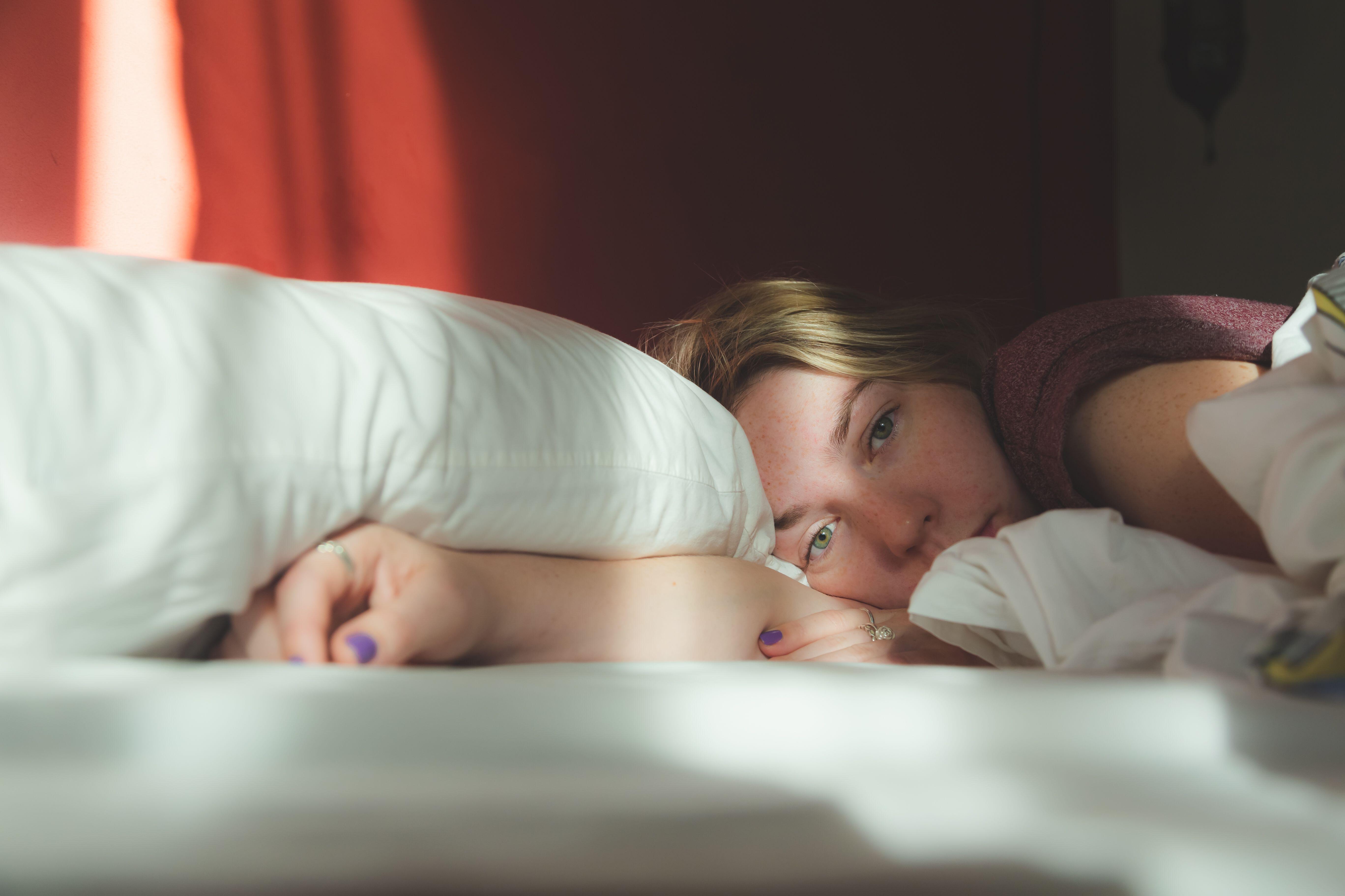 A young blonde woman laid in bed