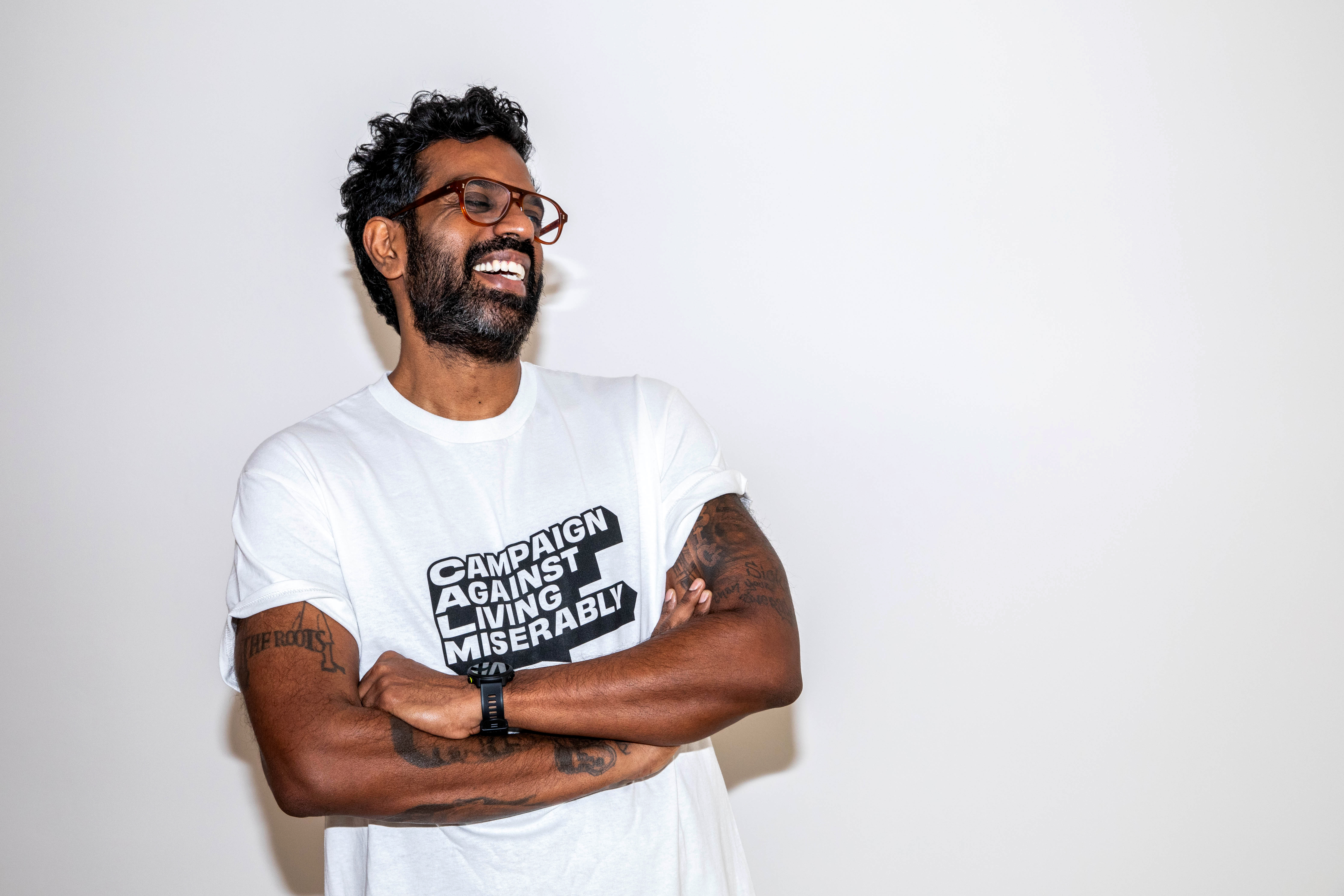 Romesh Ranganathan wearing a T-shirt for Campaign Against Living Miserably charity