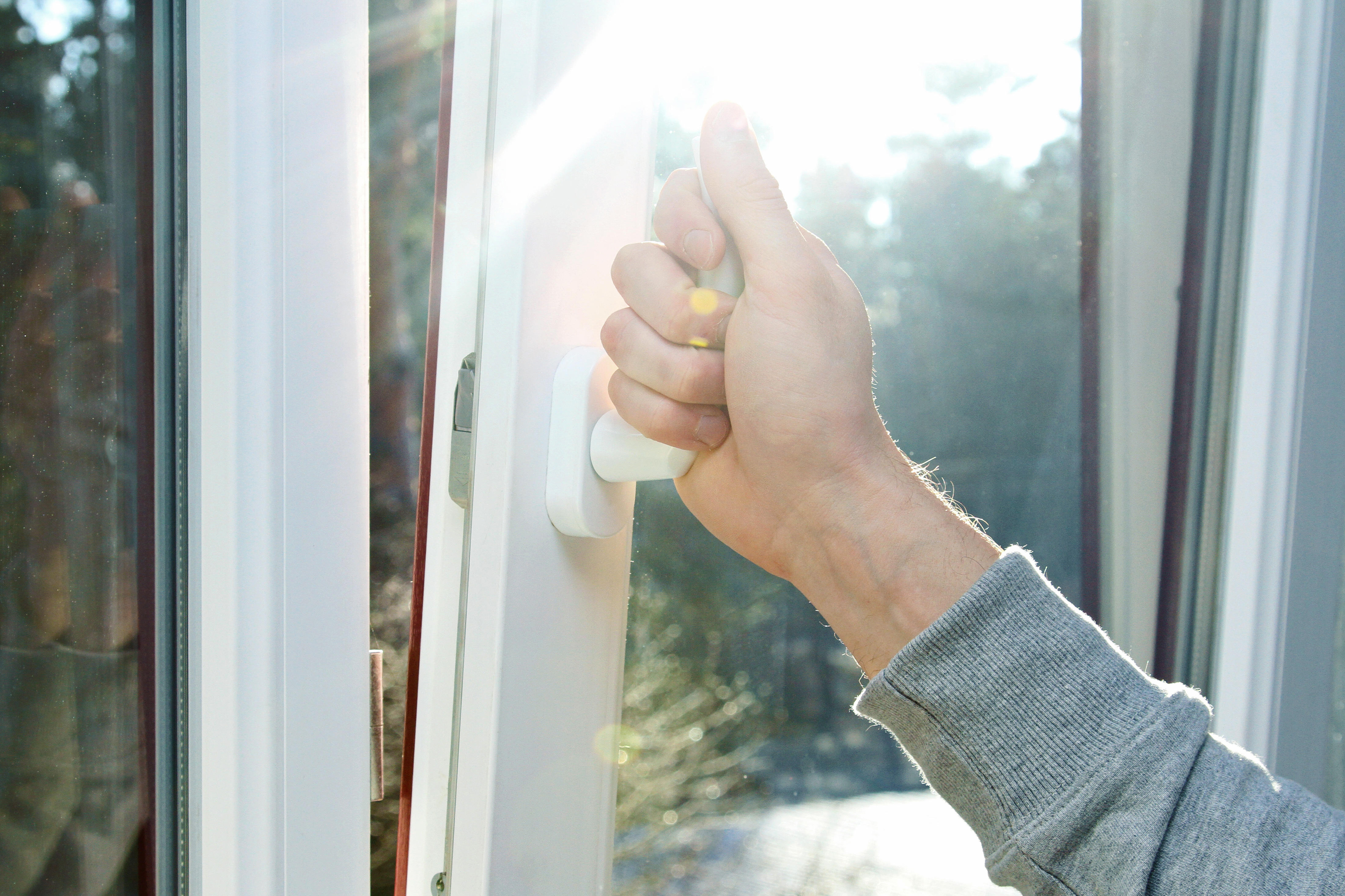 Man opening window to let fresh air in