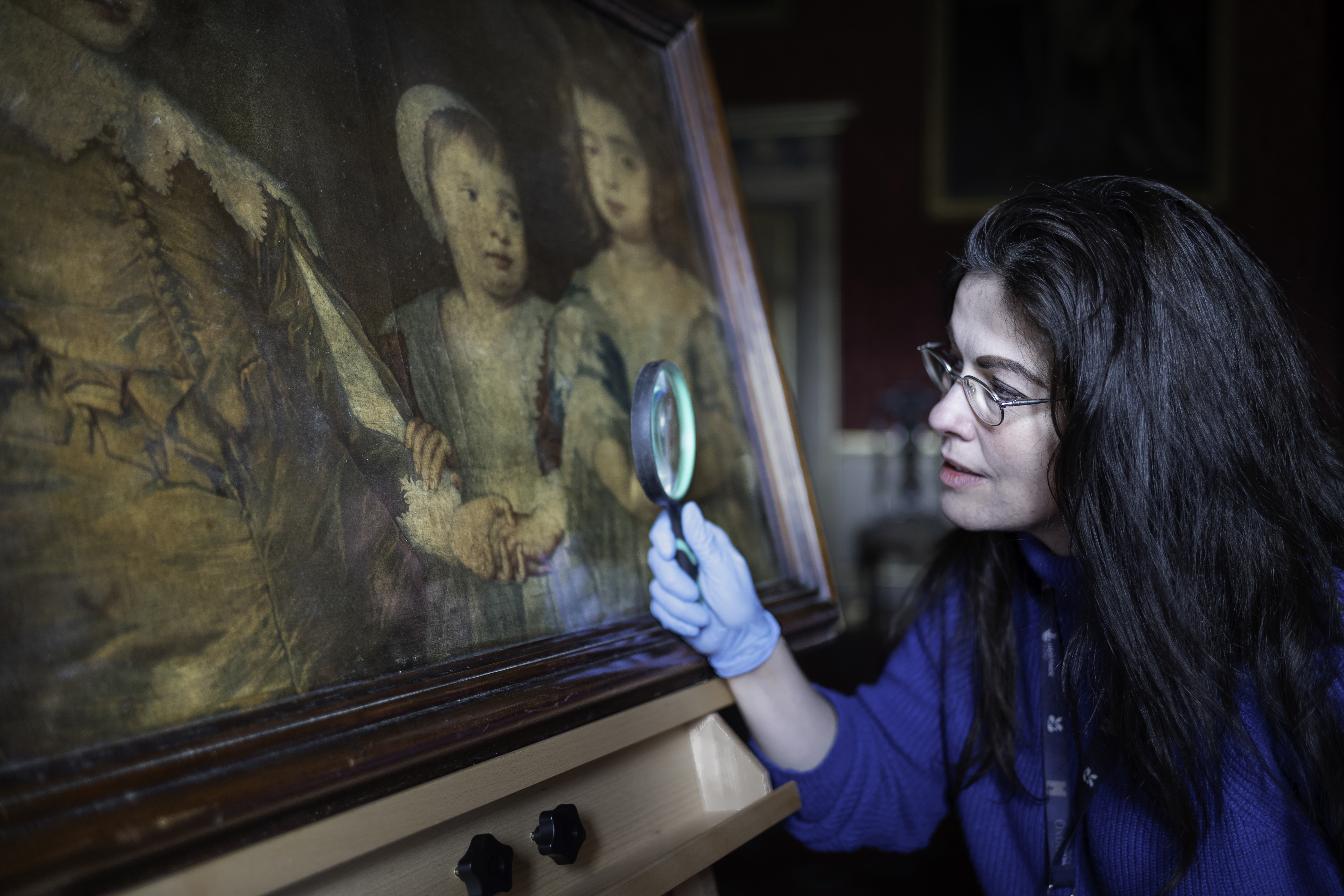 A curator inspects the recently discovered print by the 18th Century printmaker Jacob Christoff Le Blon at Oxburgh Hall in Norfolk. (Mike Hodgson/ National Trust/ PA)