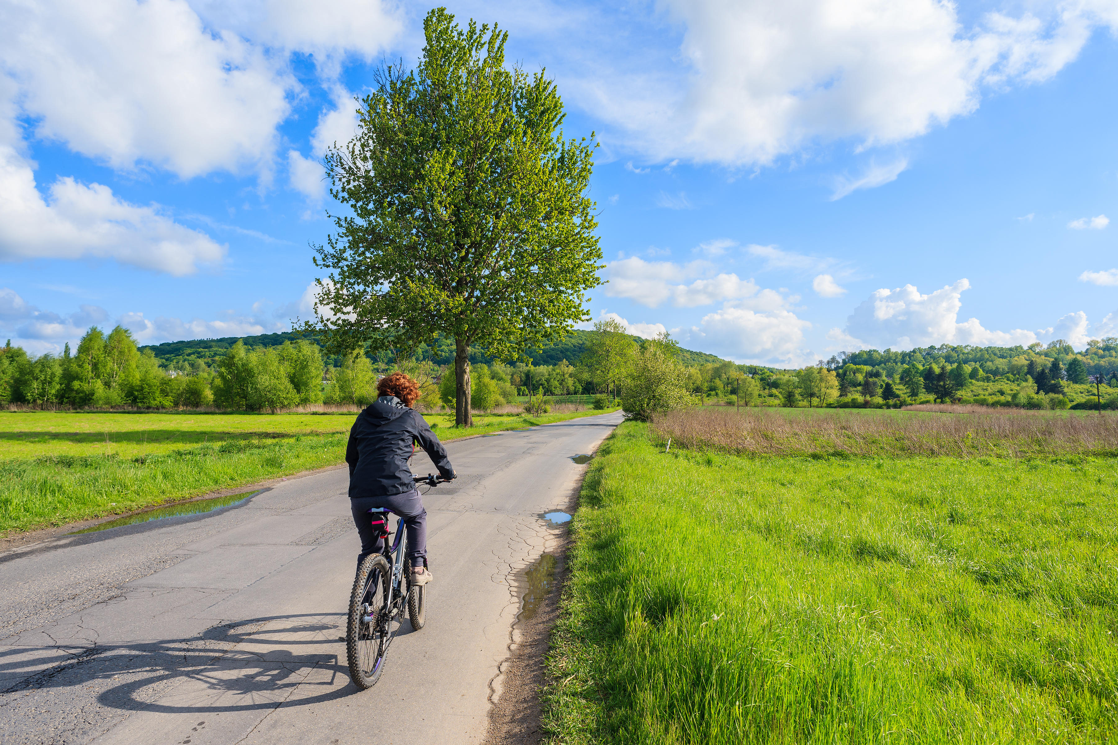 A woman riding a bike in a rural area