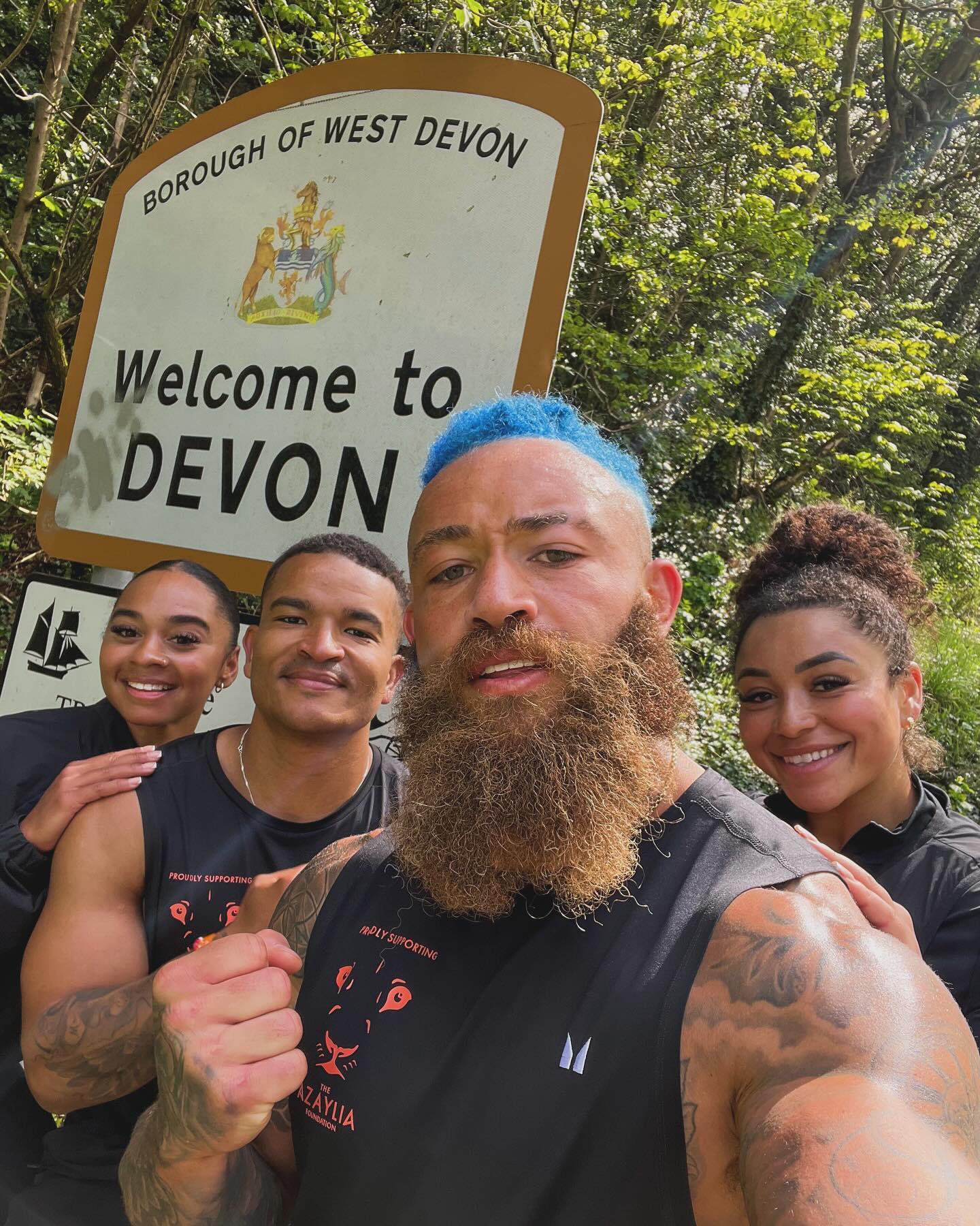 Ashley Cain in front of a Devon sign