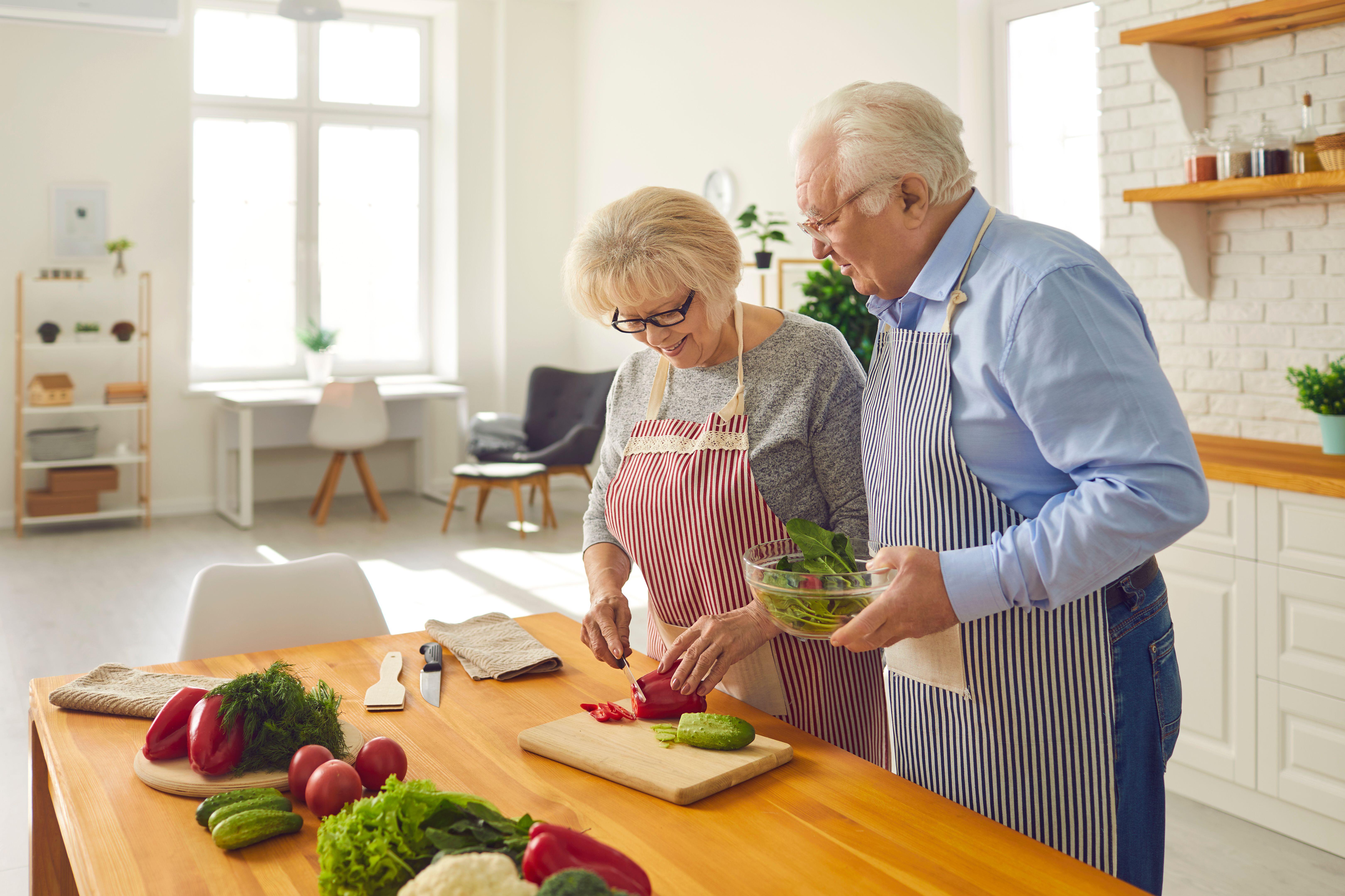 A mature couple cooking healthy food together at home