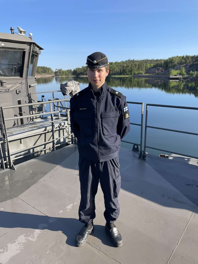Daniel Simojoki wearing his navy uniform and standing on a ship
