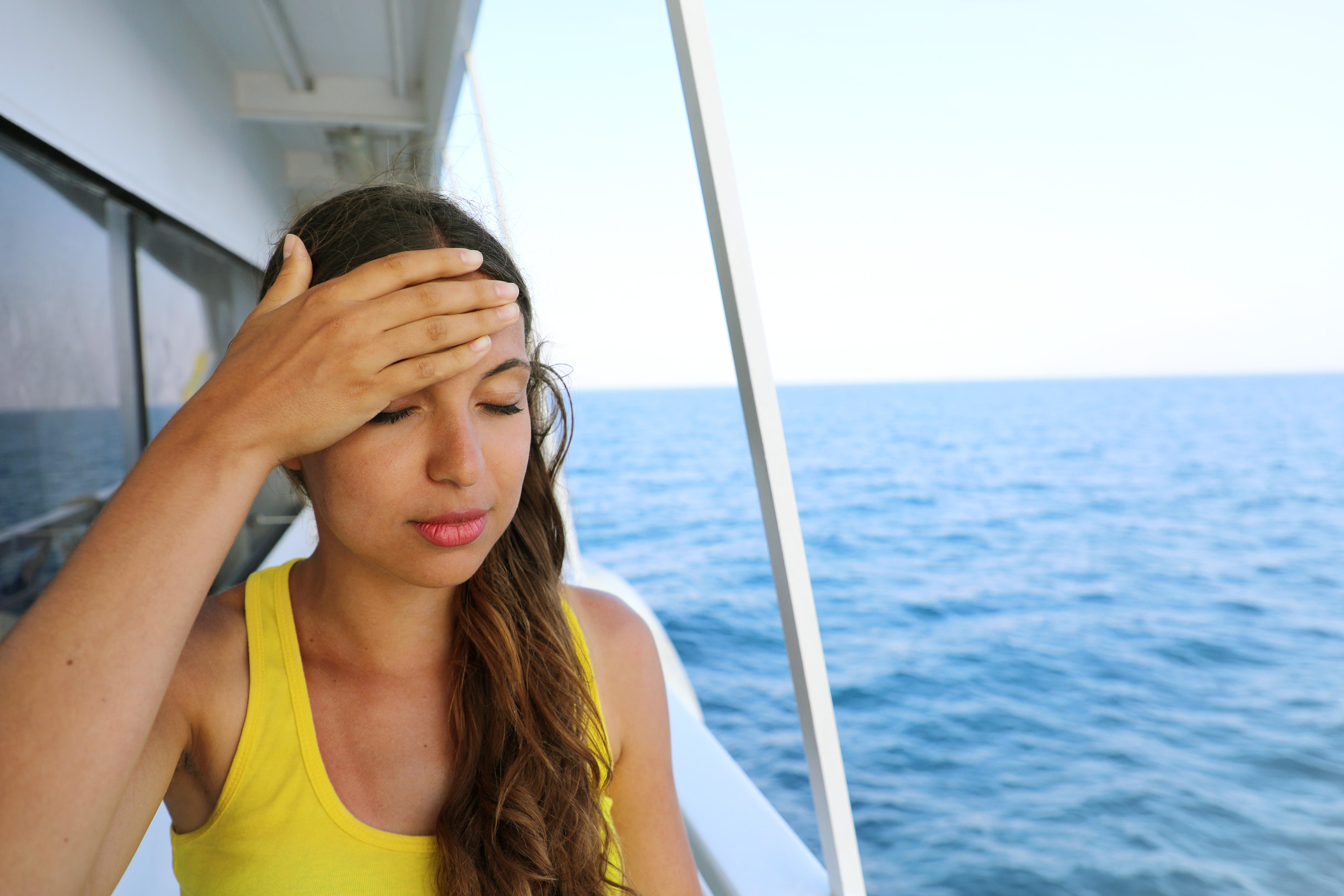 Young woman suffer from seasickness during vacation on boat. Cruise sea motion sickness tourist woman on boat vacation with headache or nausea.