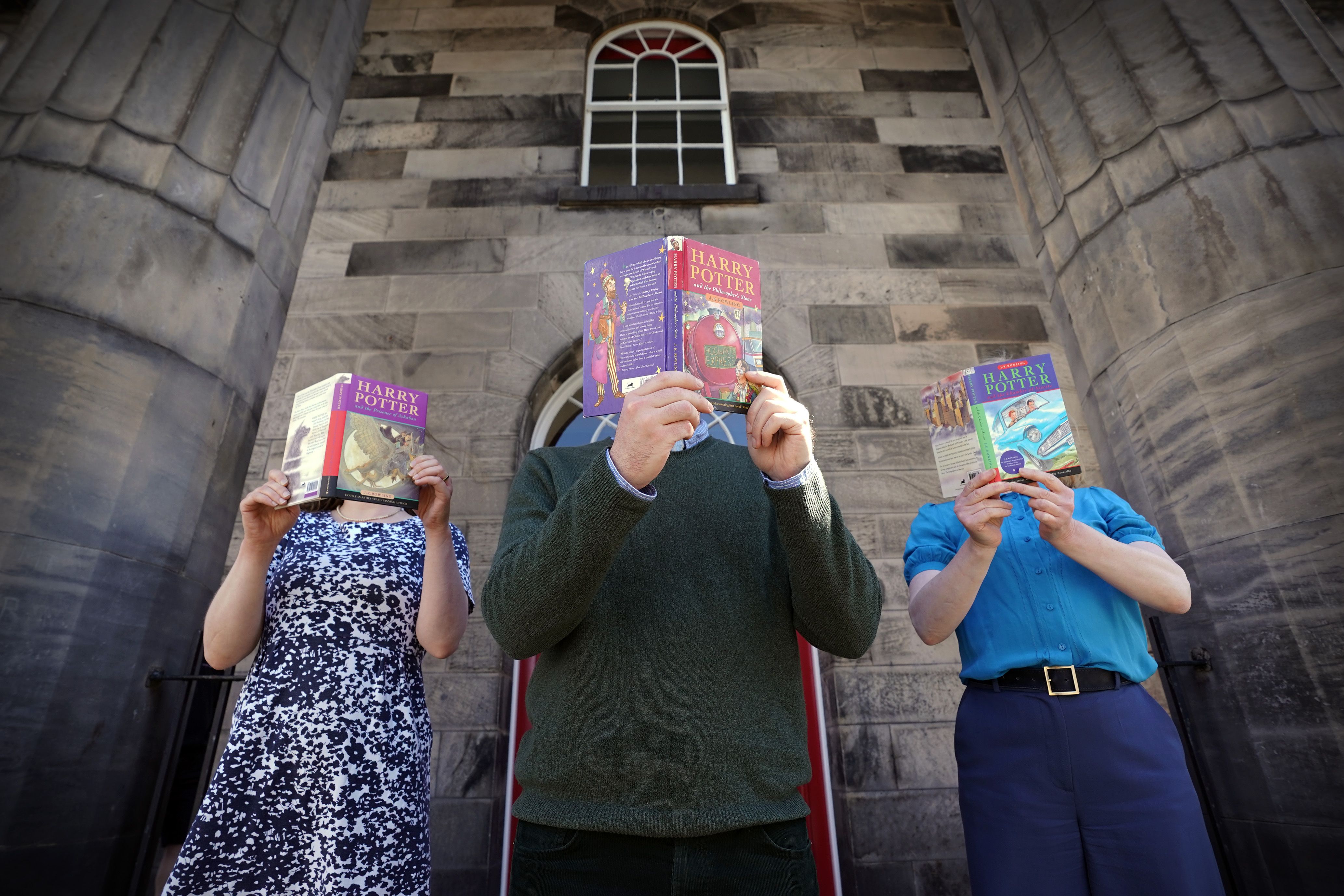 The people holding Harry Potter books in front of their faces