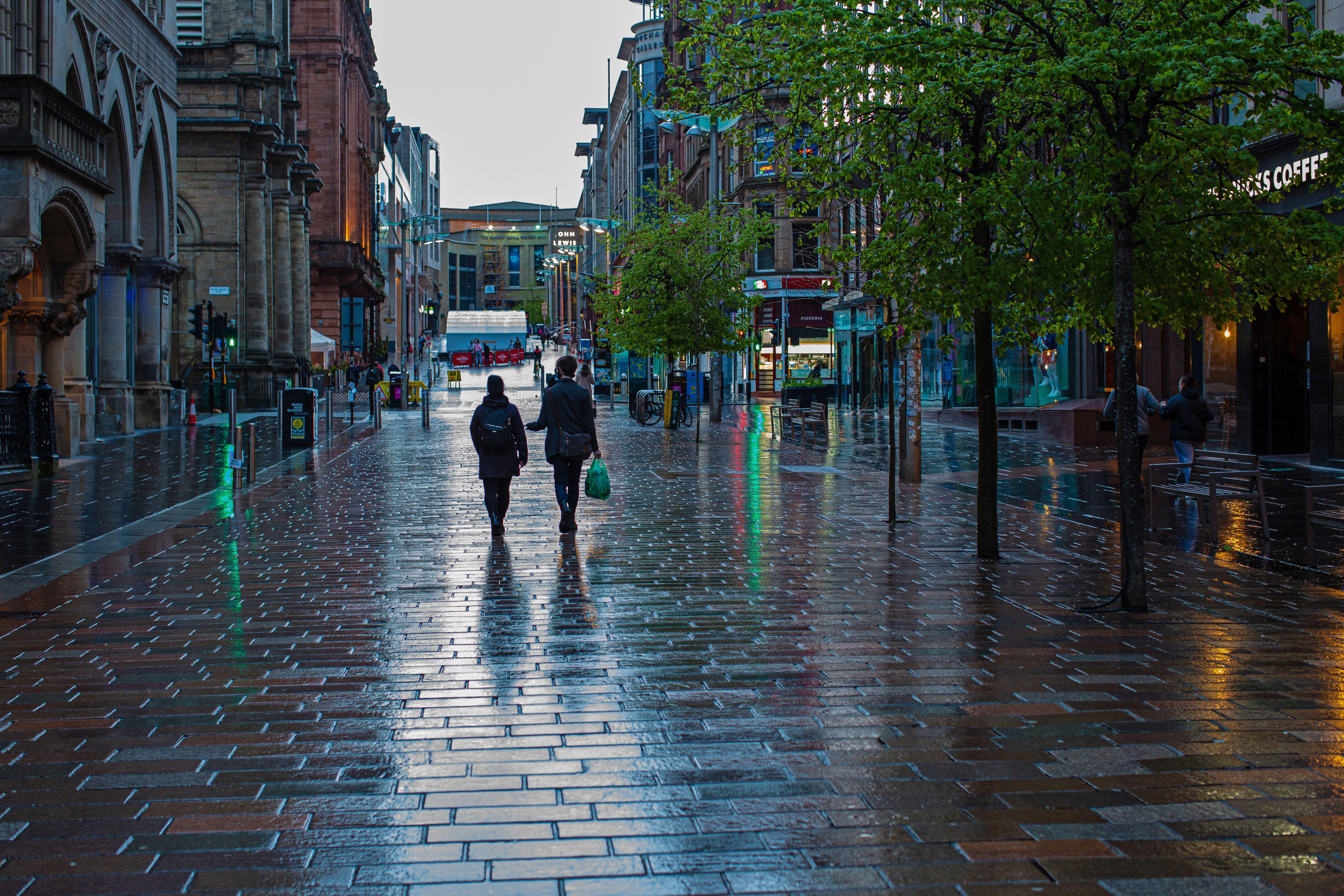 Couples walking in rainy shopping street in Buchan Street central Glasgow