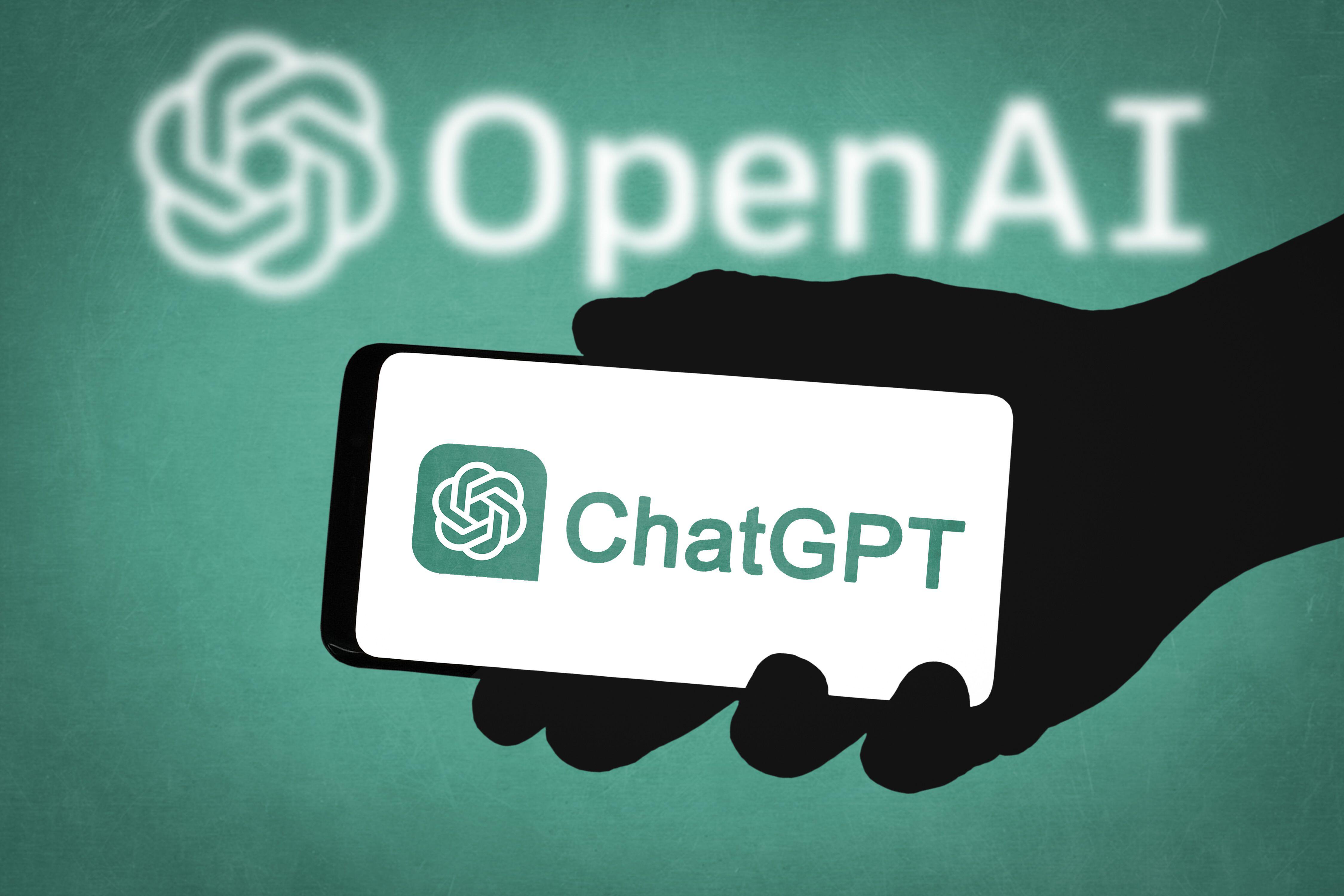 A hand holds a phone with the ChatGPT logo on the screen and OpenAI logo in the background