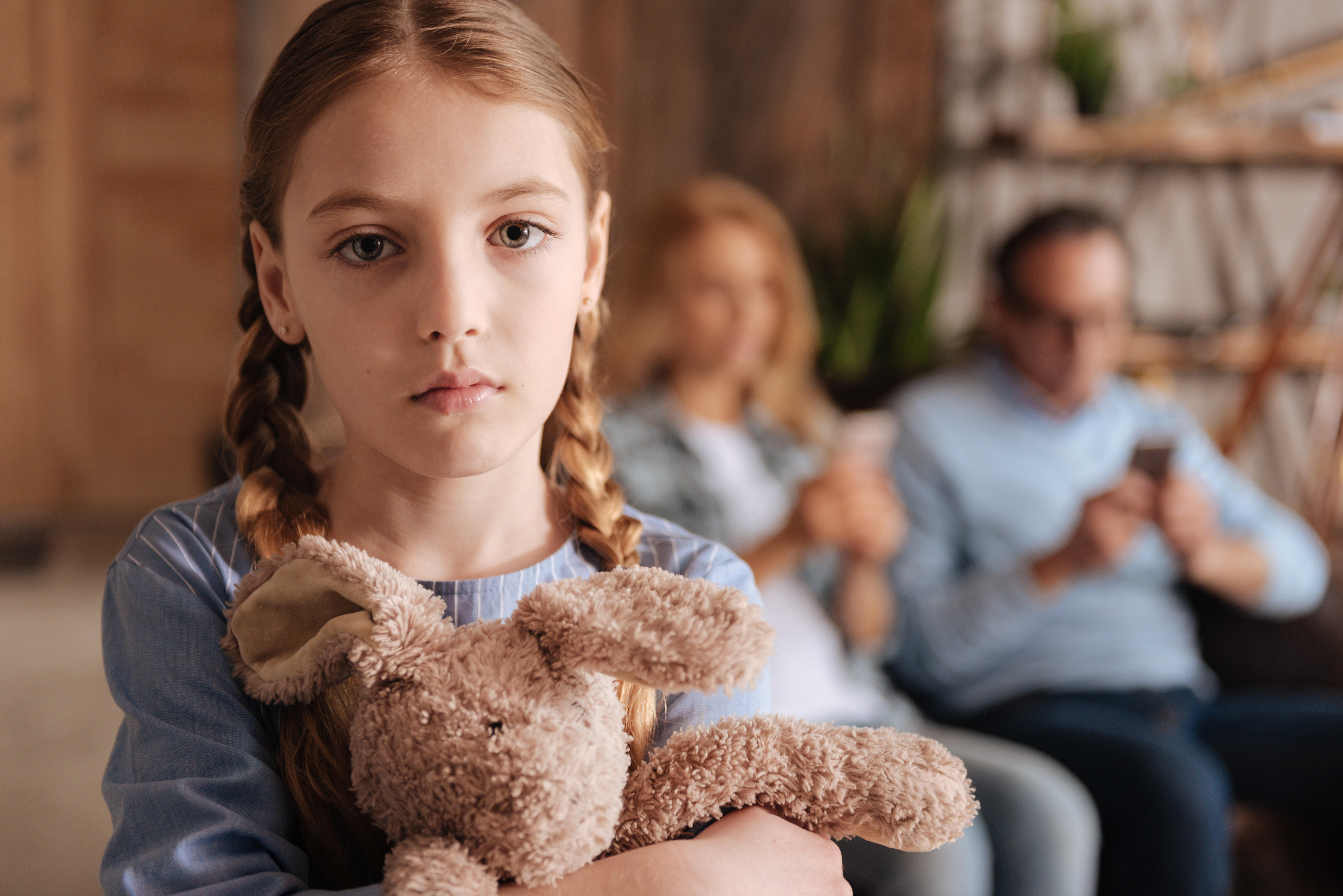 Depressed small girl expressing sadness at home