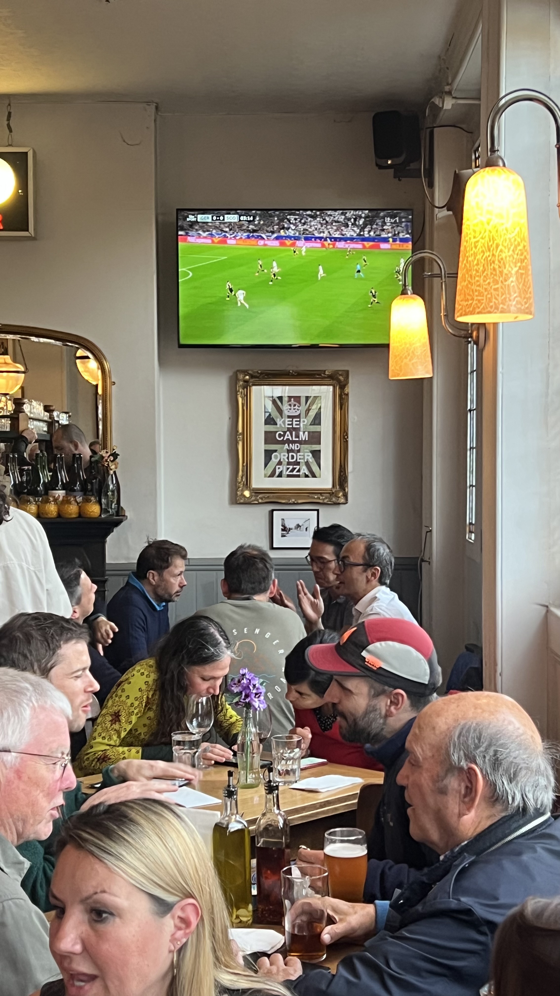 People sitting in the Mitre with a TV mounted on a wall overhead
