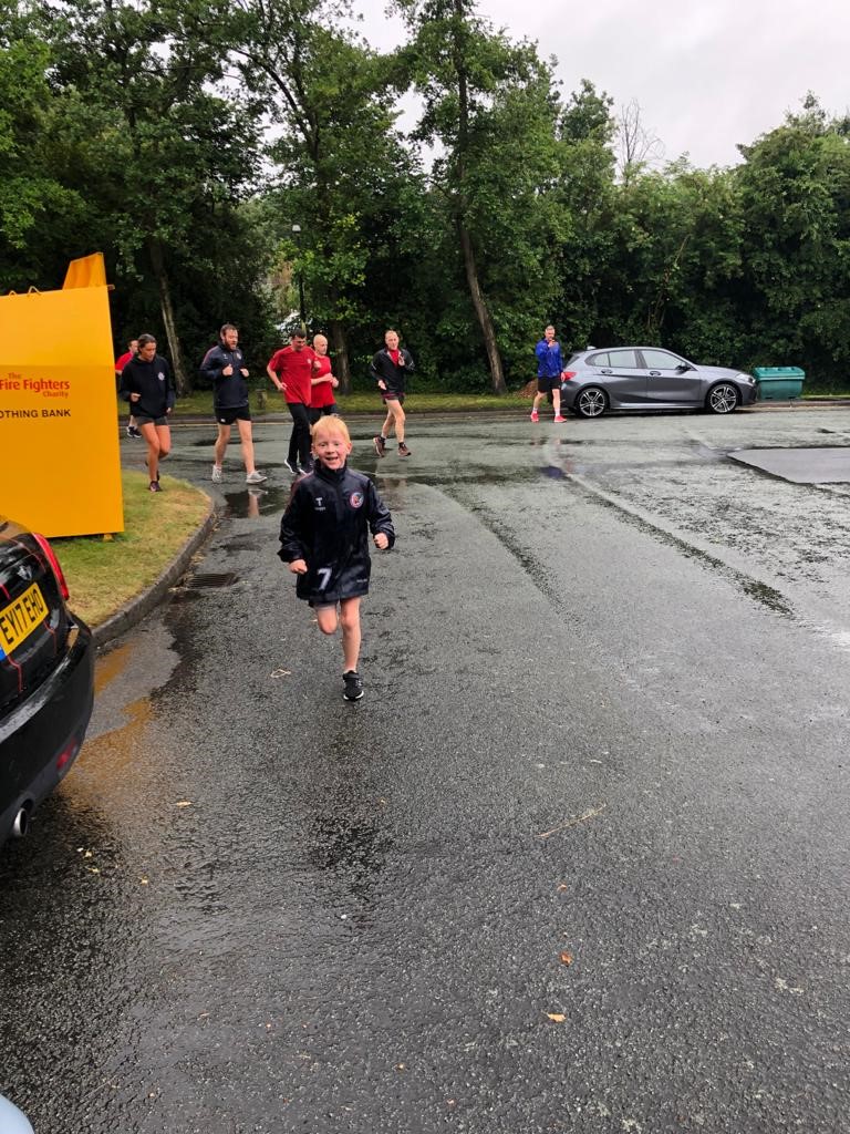 Young boy runs in the rain for fundraiser