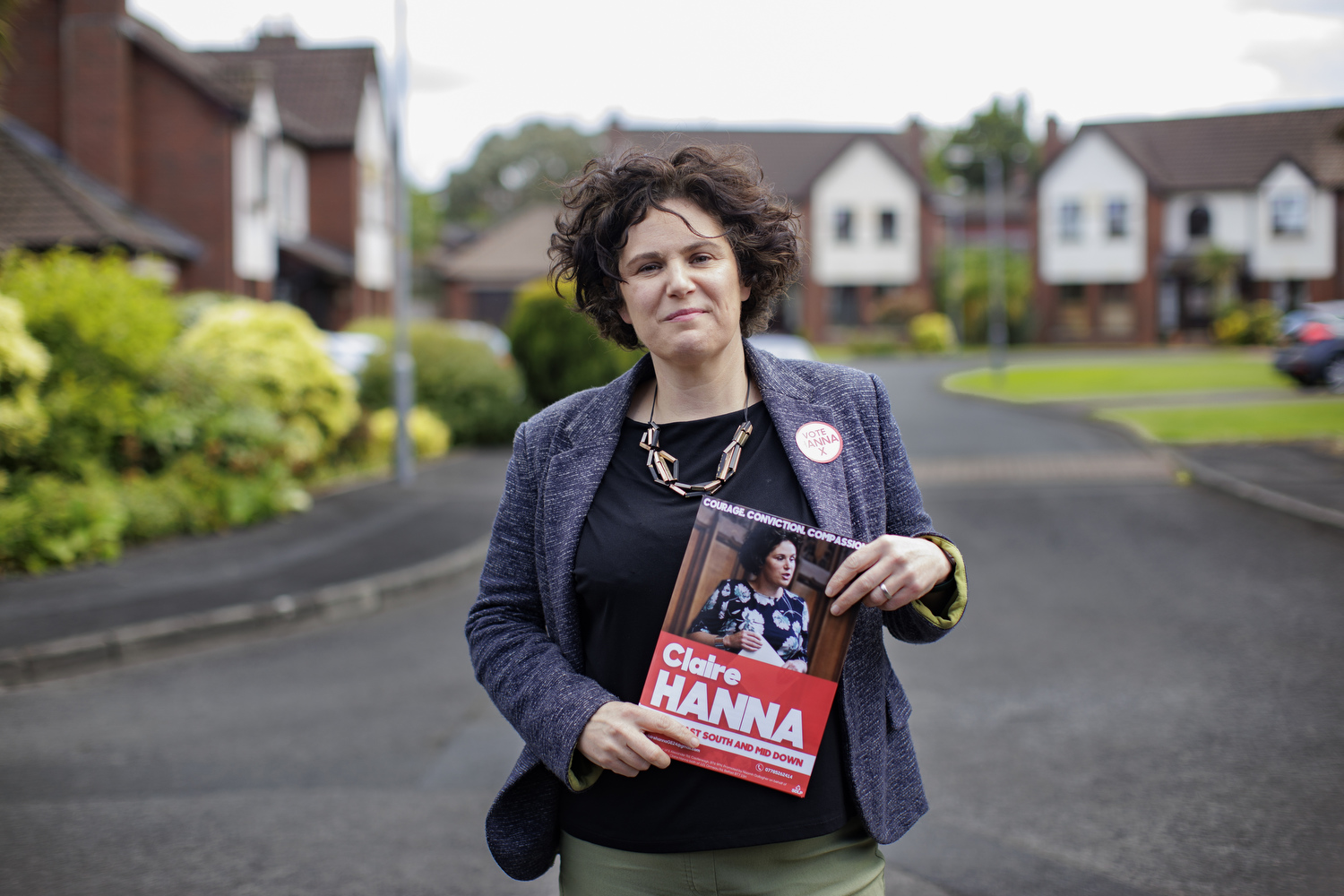 Claire Hanna standing in a residential area of Carryduff holding her own election material