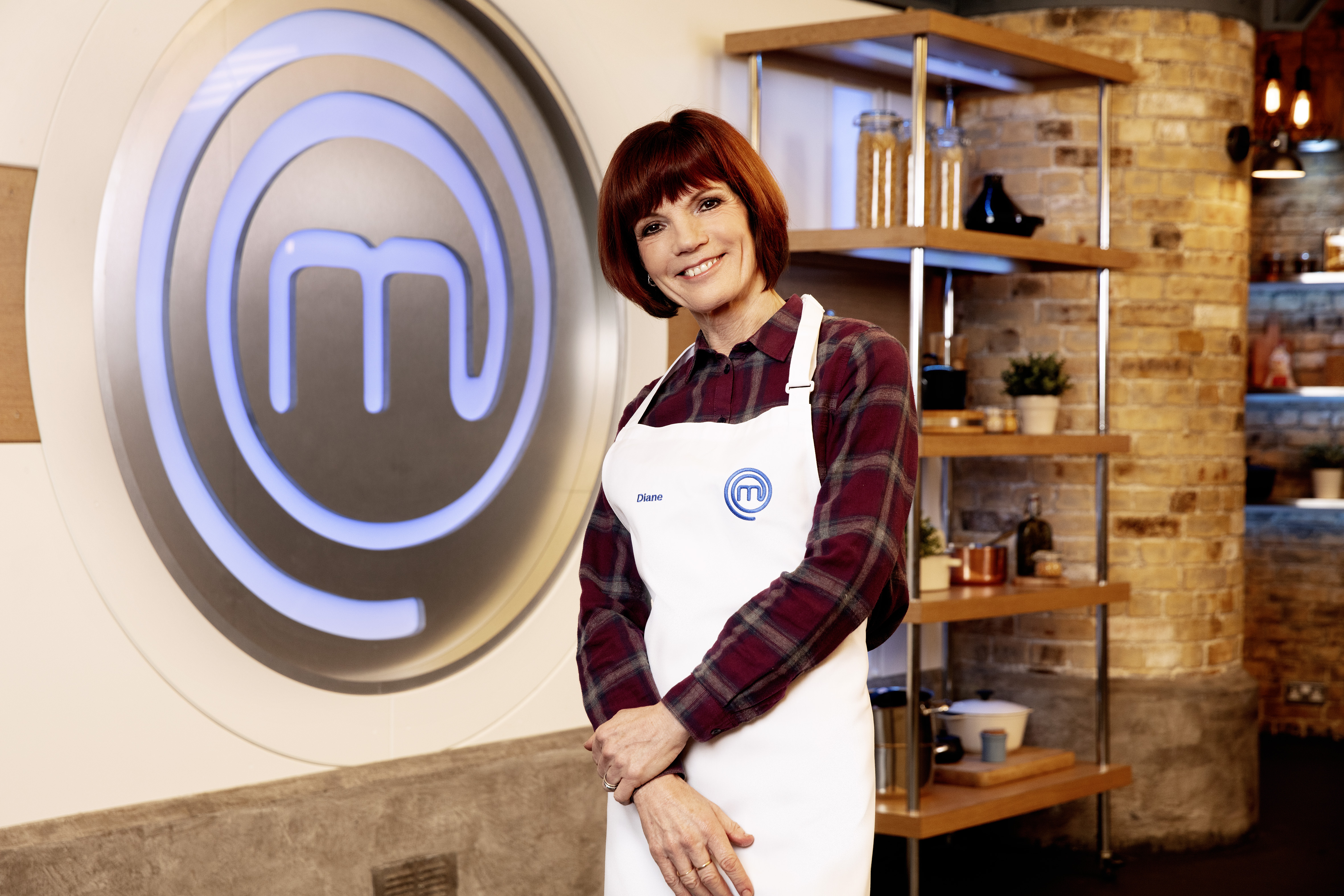 Diane Carson from The Traitors smiles while standing in the Celebrity MasterChef kitchen