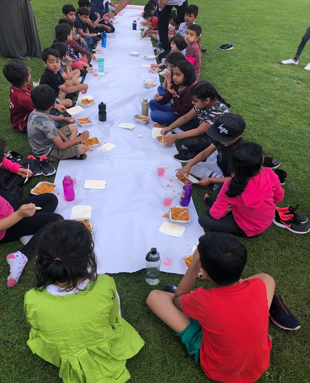 Children at a 2019 school holiday camp enjoy a hot meal together at Mount Cricket Club