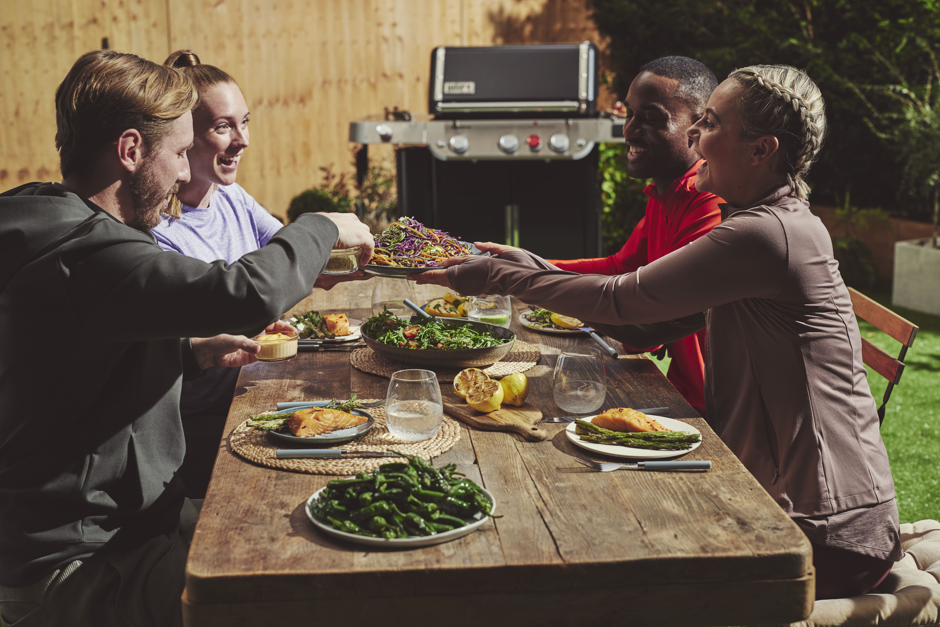 Friends enjoying a BBQ in summer sunshine