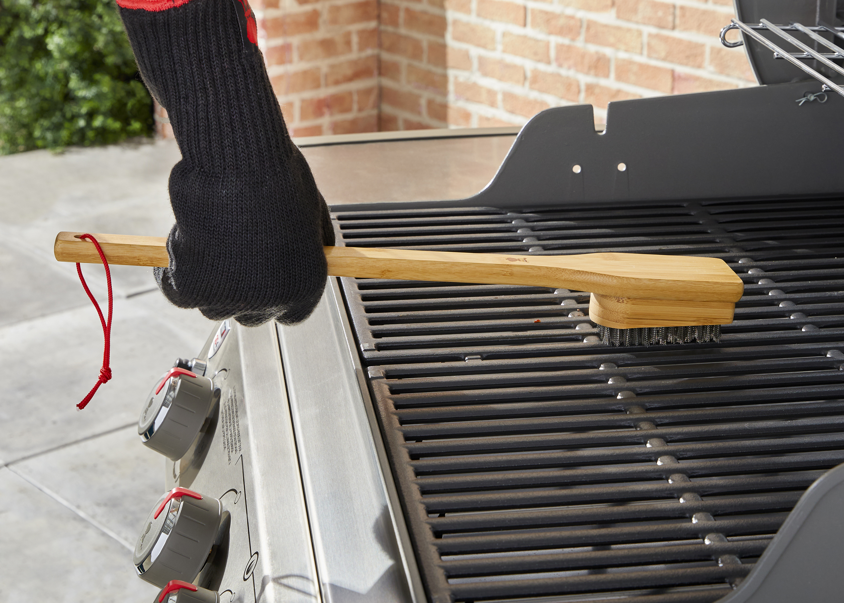 Man cleaning BBQ with a grill brush