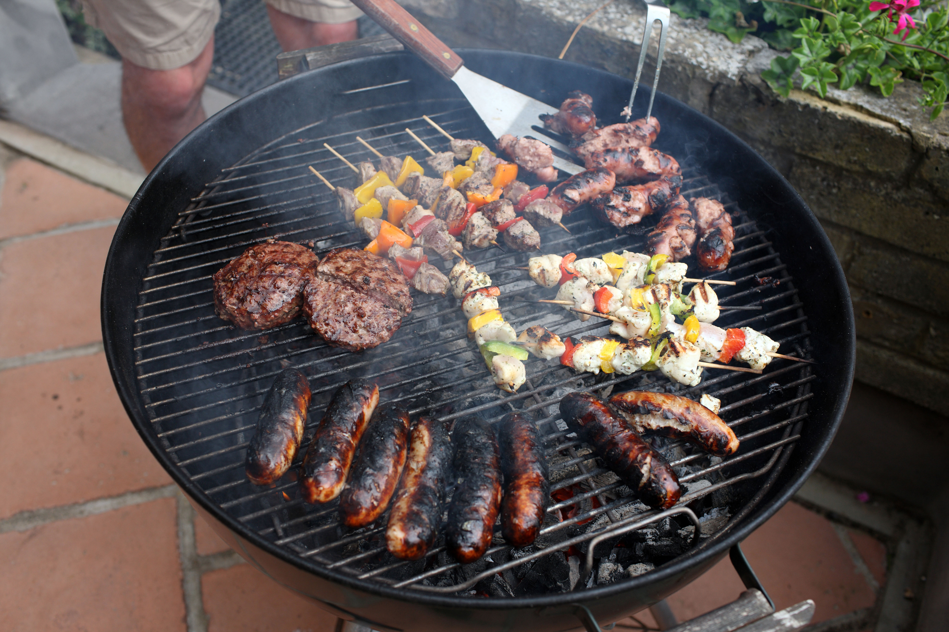 Man grilling food on kettle BBQ