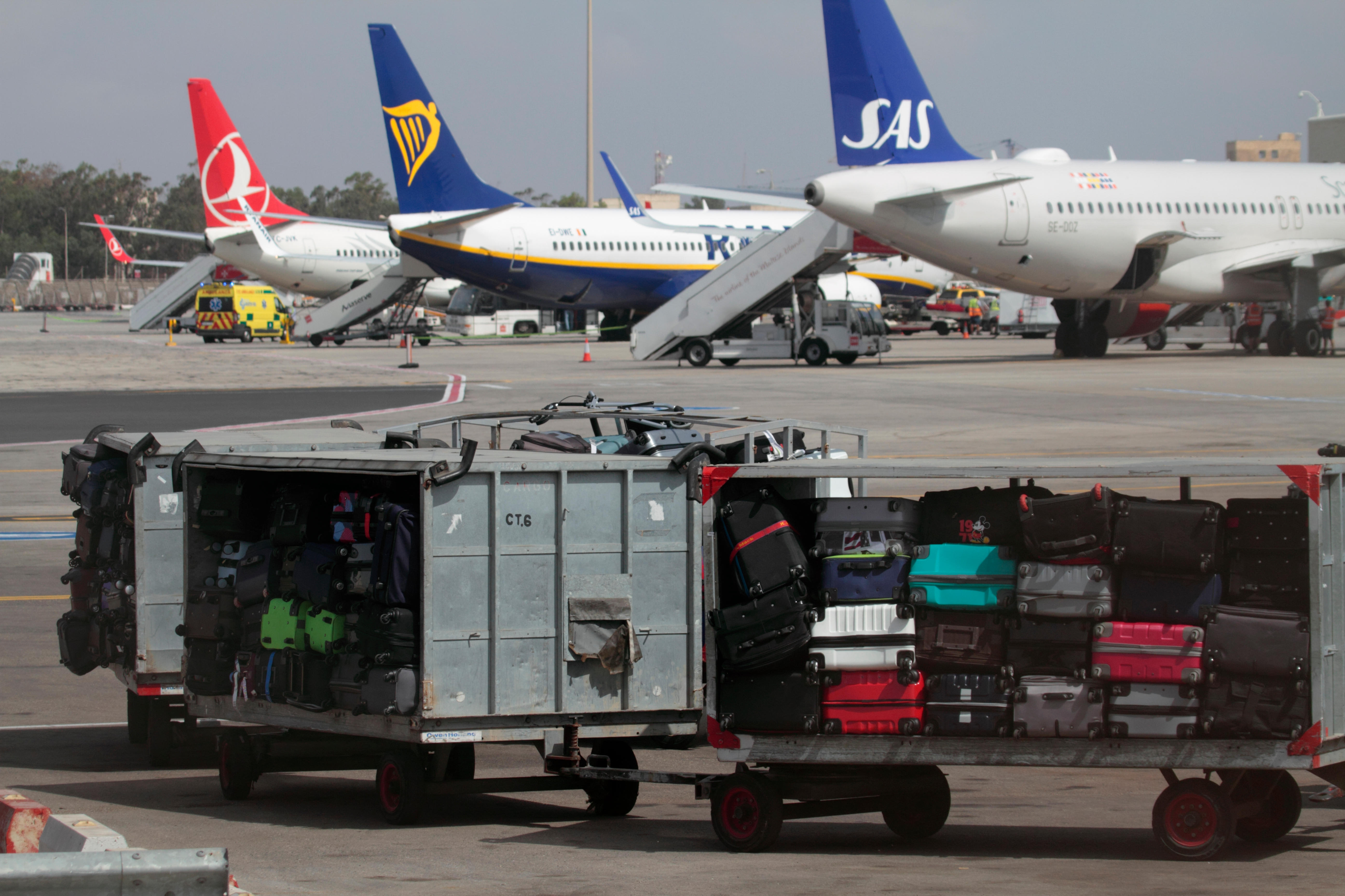 P13C39 Airport luggage trolleys waiting to be towed to an aircraft on the apron in Malta. Baggage handling at airports in the EU. Air travel.