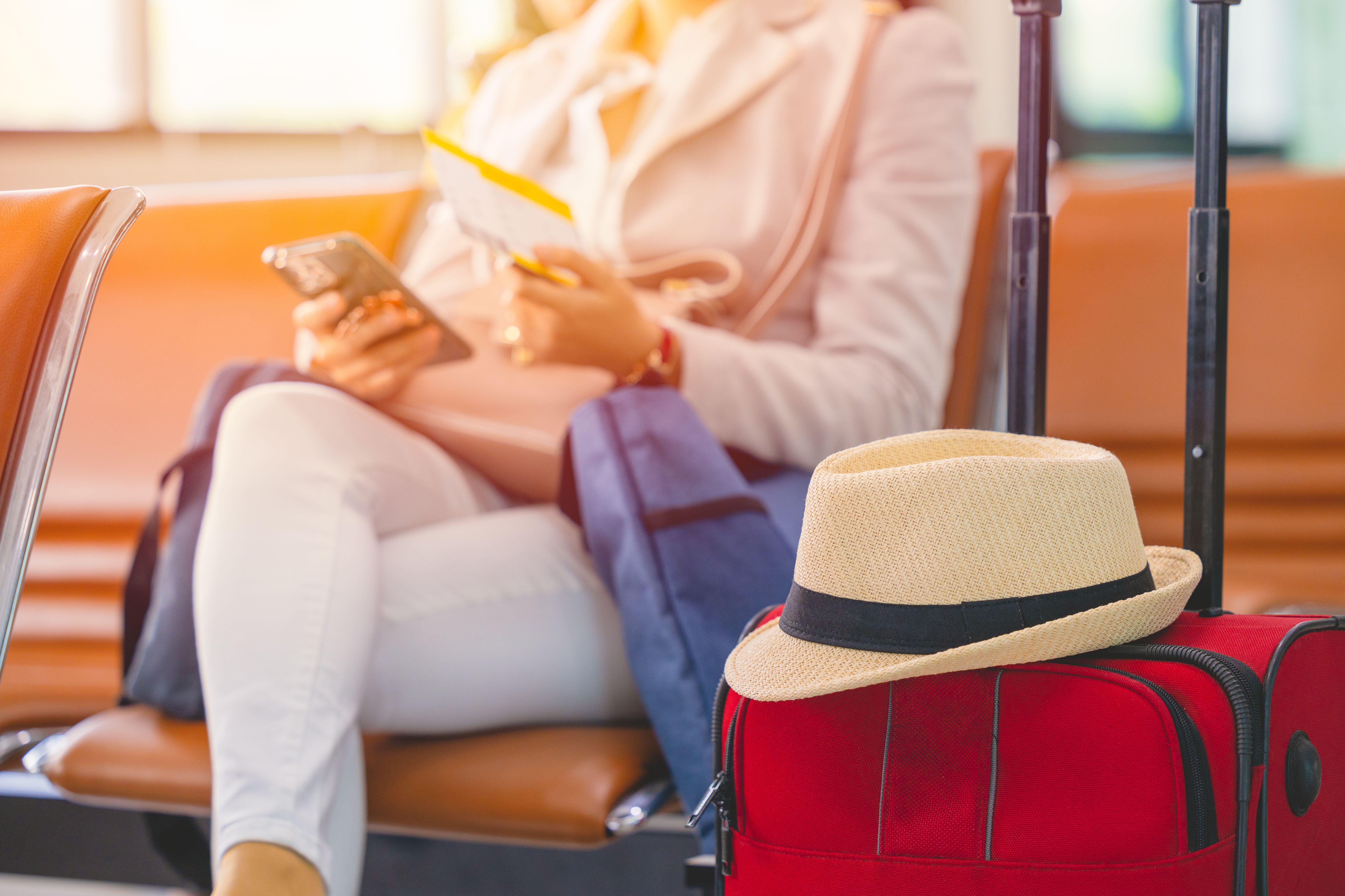 Single woman Travel luggage and ticket waiting for vacation flight in airport.