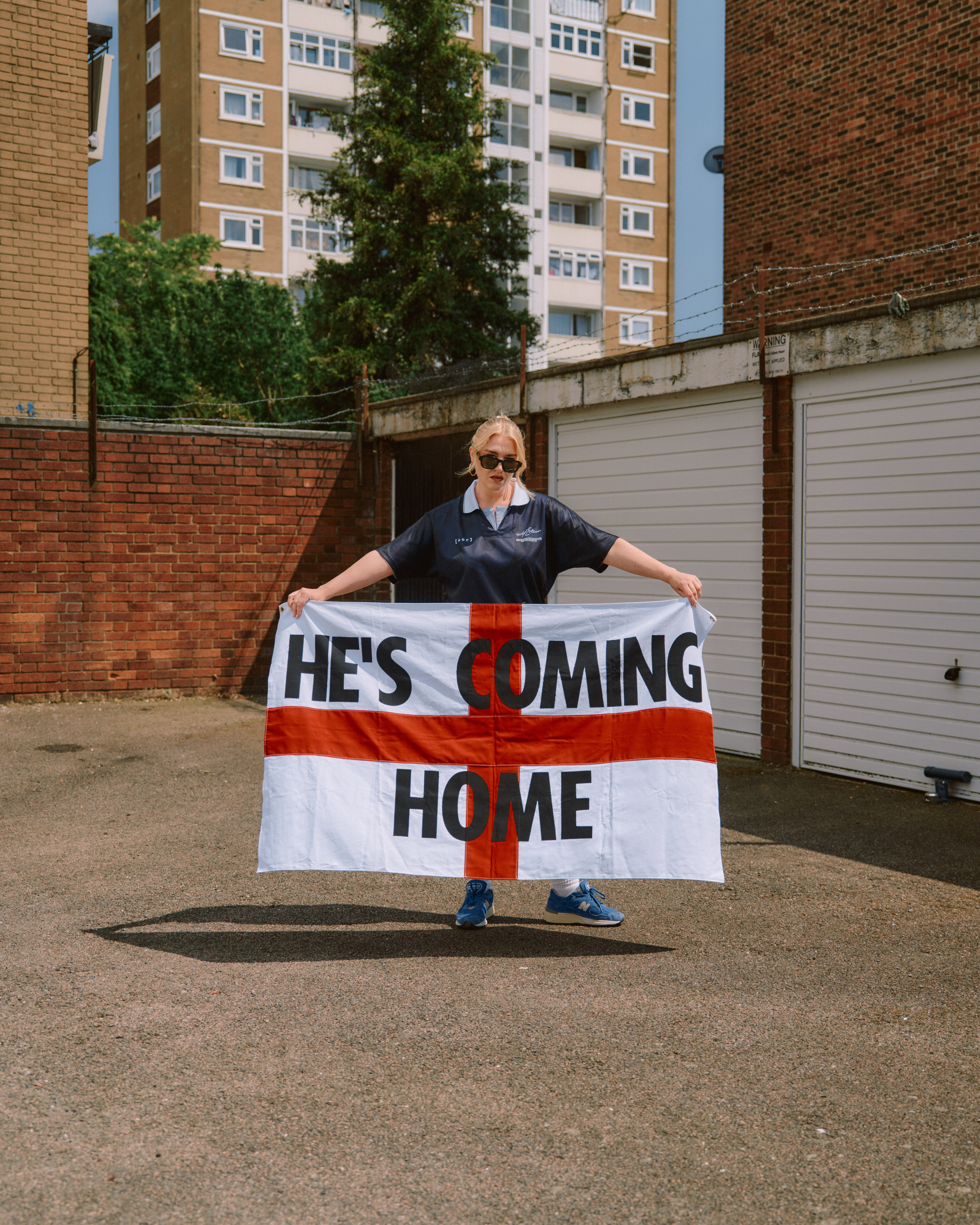 Self Esteem with an England flag with the words "he's coming home" on it