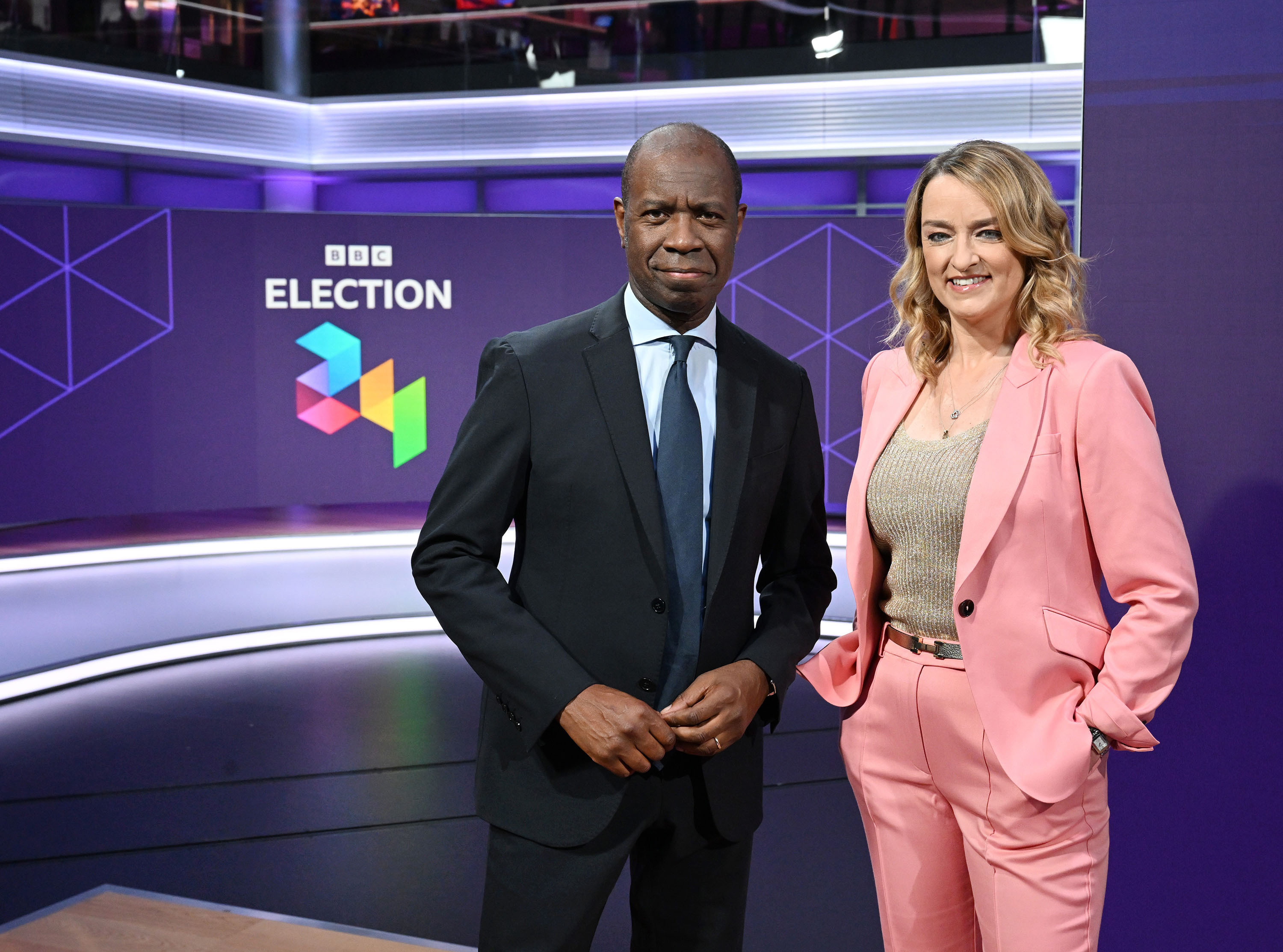 Clive Myrie and Laura Kuenssberg standing in a BBC News election studio