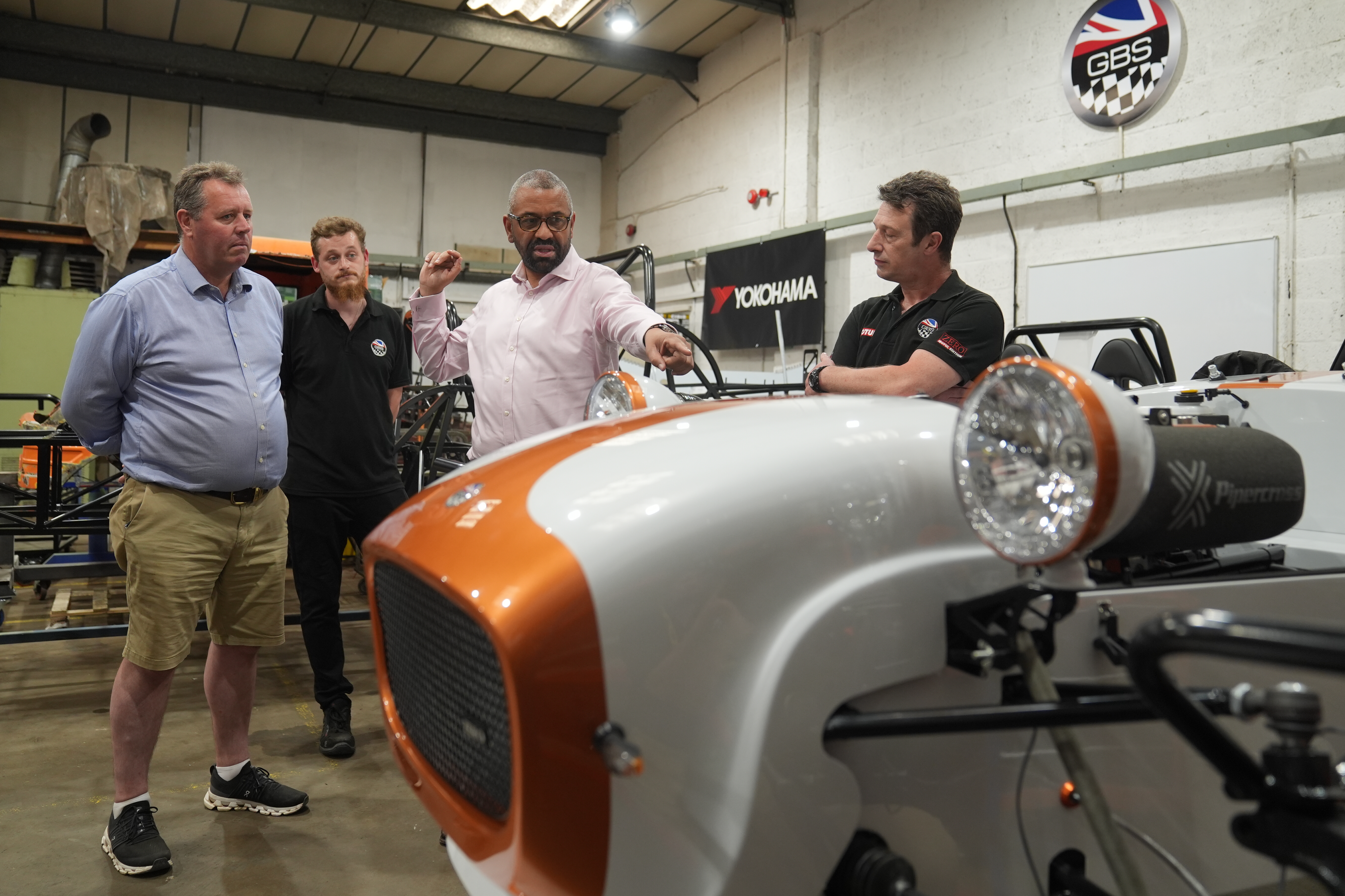 James Cleverly gestures at a classic sports car