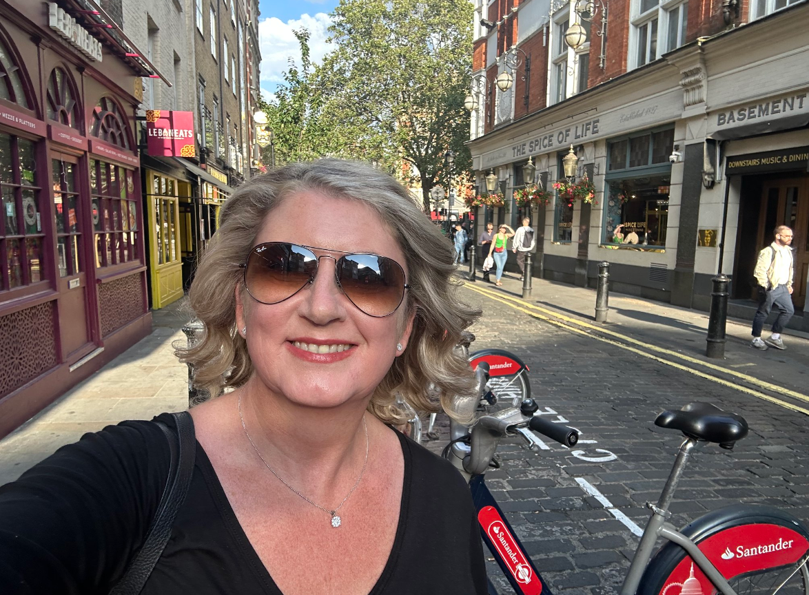 Woman wearing sunglasses takes selfie on a street in London